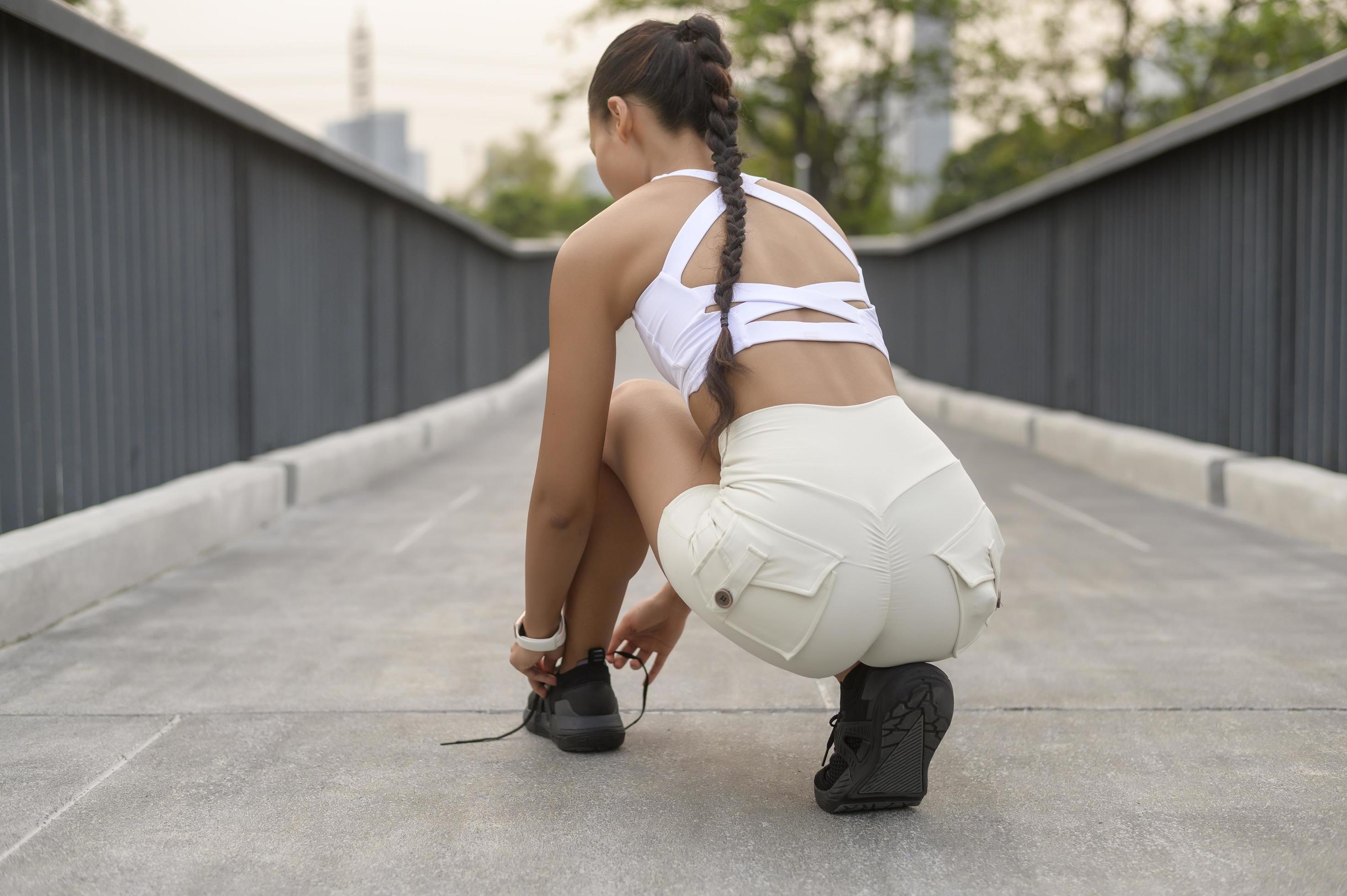 Young fitness woman in sportswear tying shoelace in city park, Healthy and Lifestyles. Stock Free