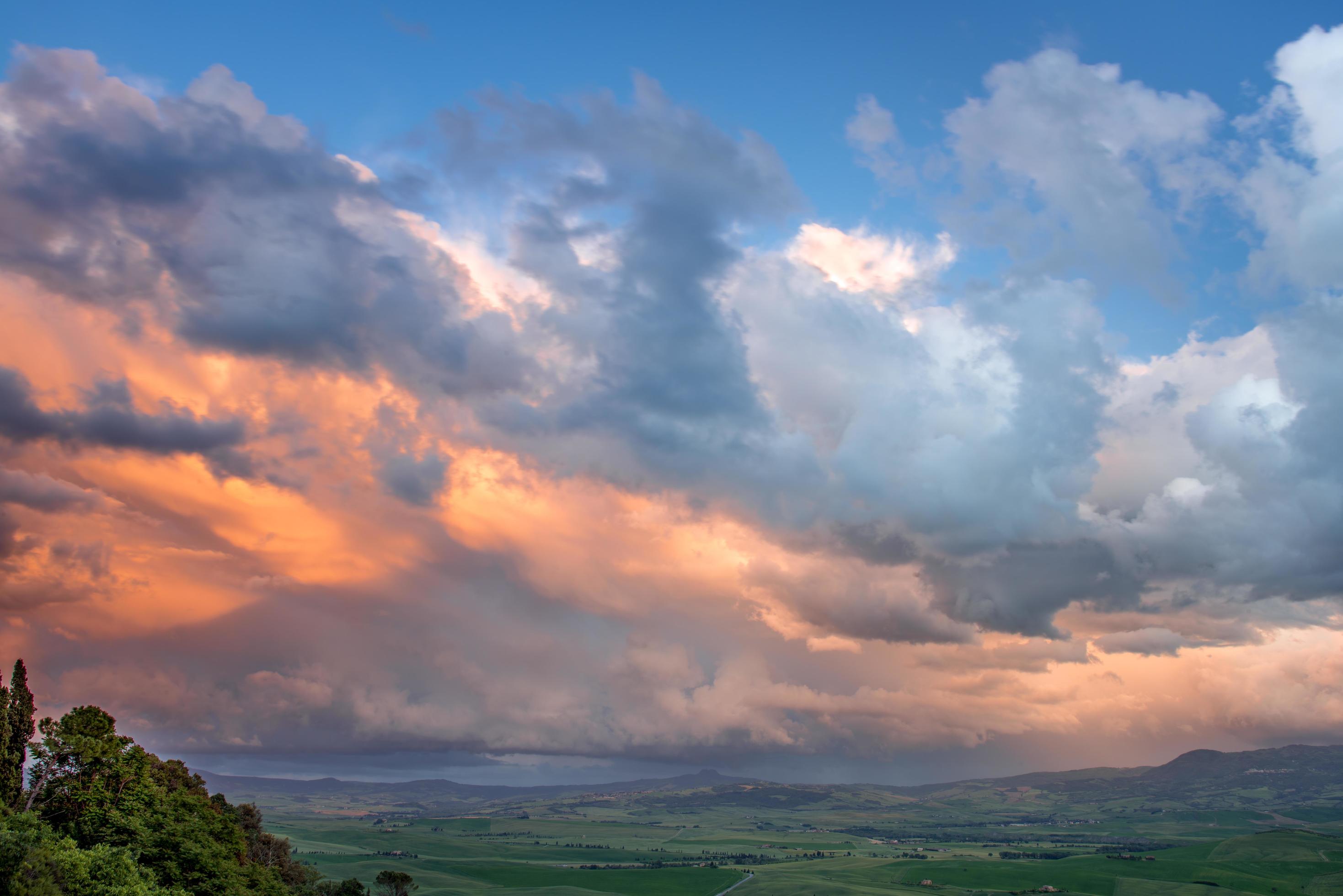 Sunset lighting up clouds over farmland near Pienza in Tuscany Stock Free