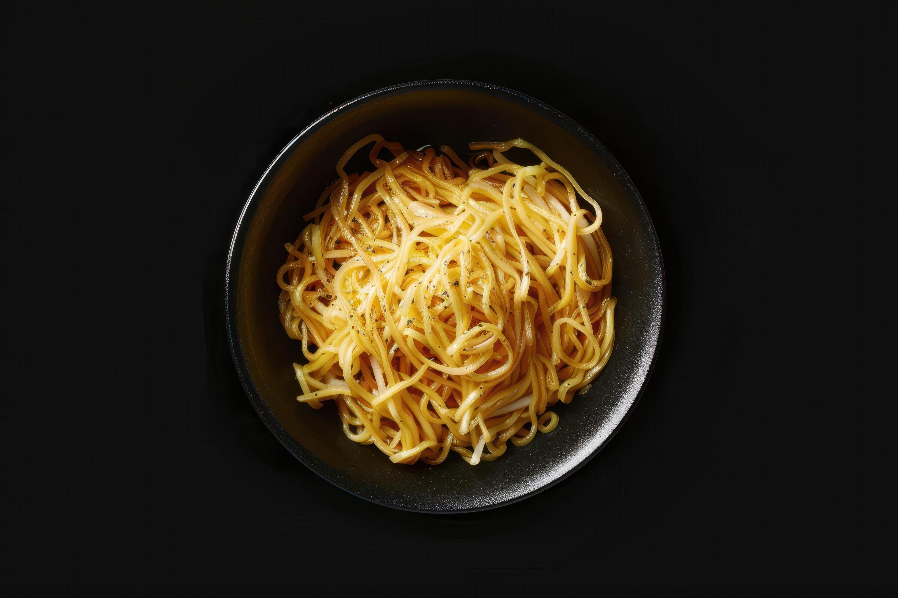 A plate of golden noodles on a black background Stock Free