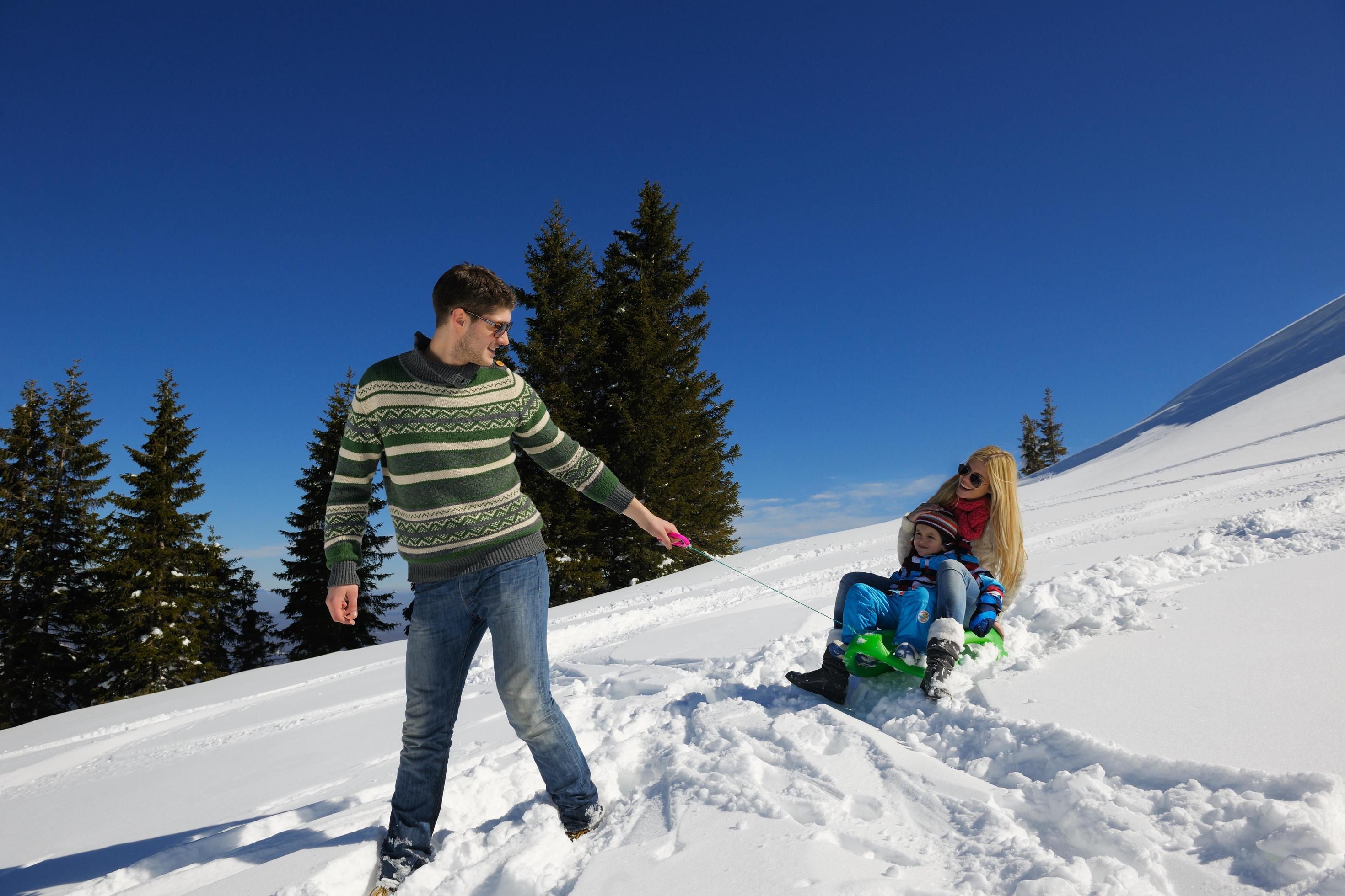 family having fun on fresh snow at winter vacation Stock Free