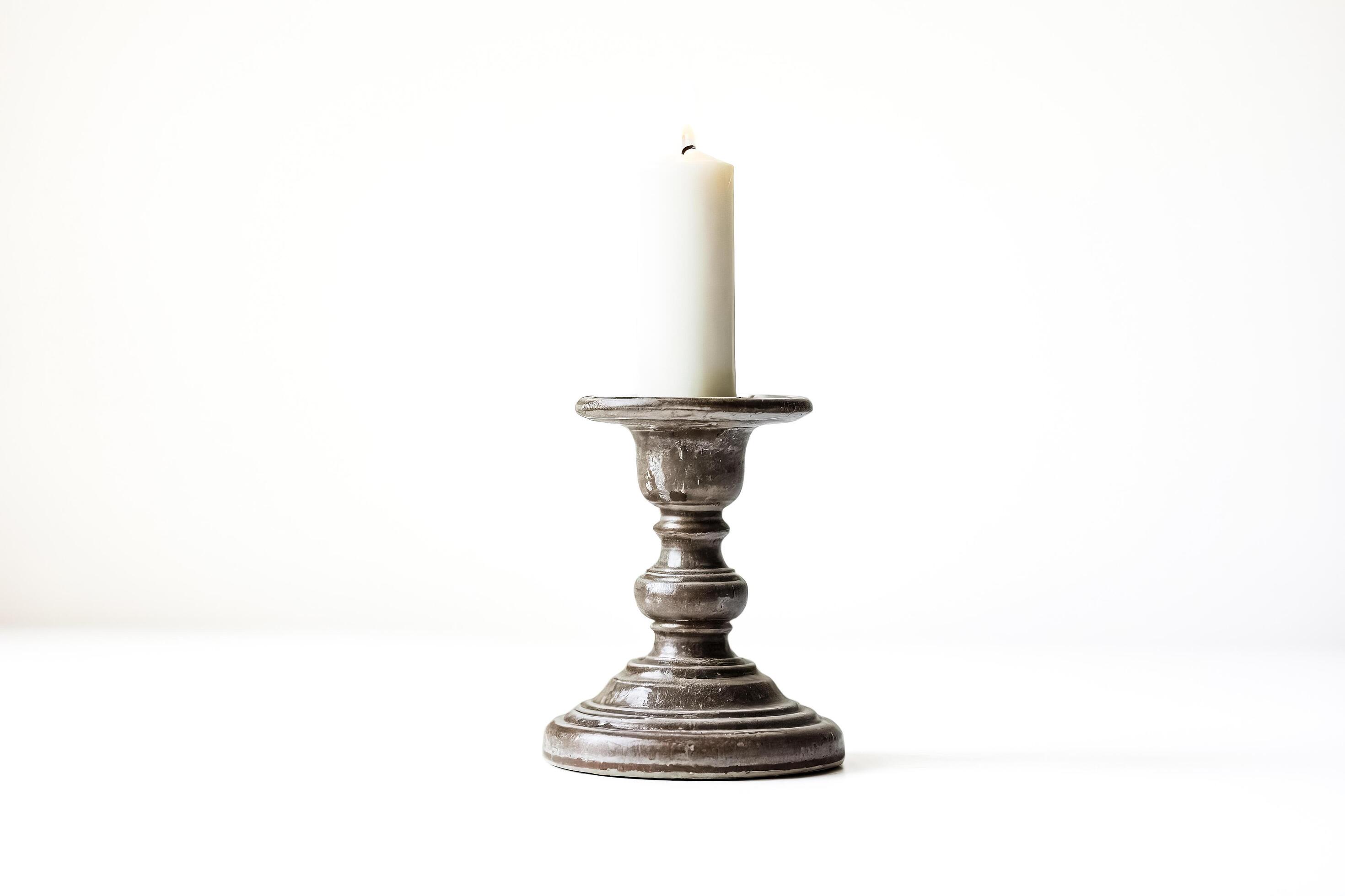 Single candle in candlestick on white background Stock Free