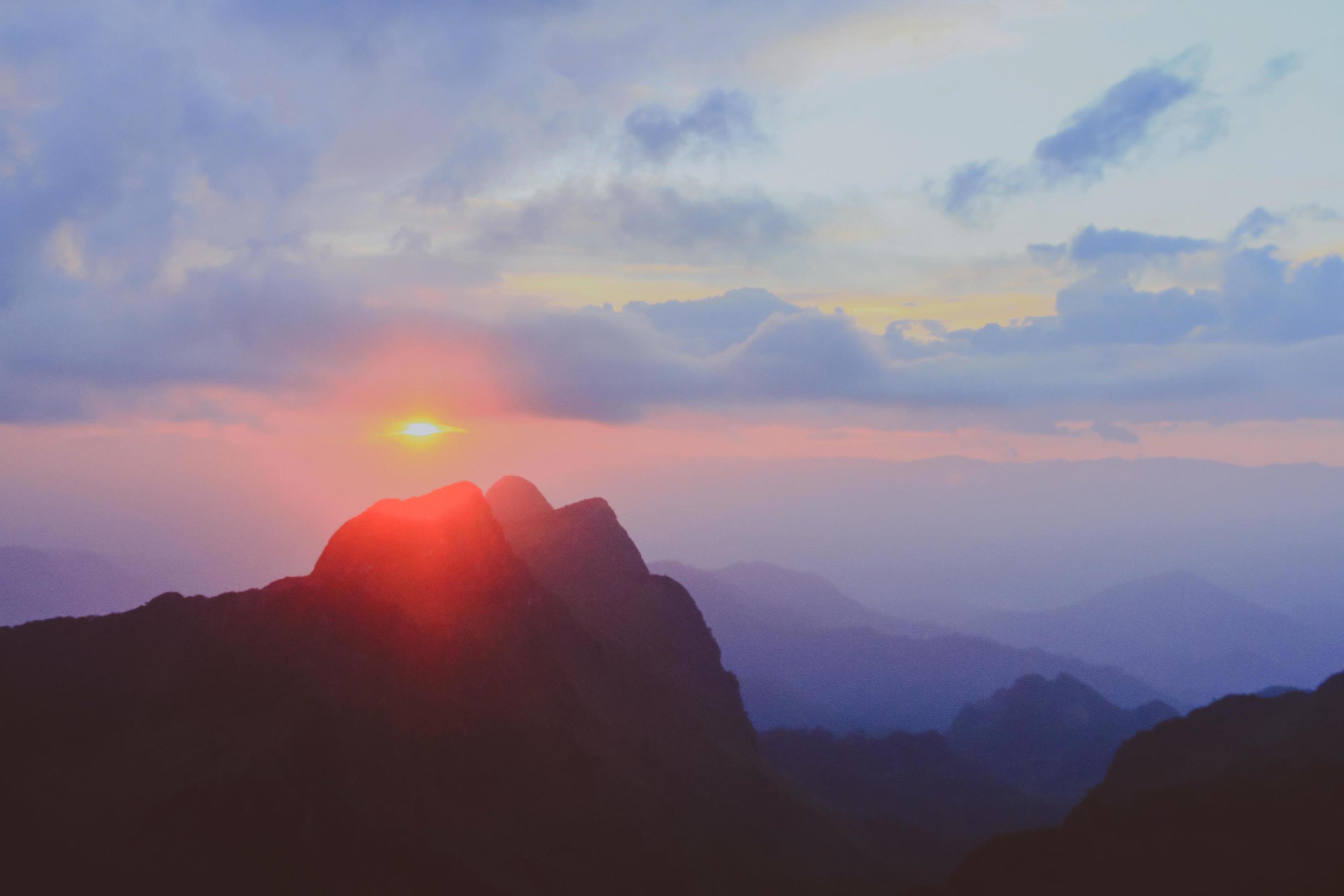 Sunset in sky and cloud, beautiful colorful twilight time with silhouette of mountain. Stock Free