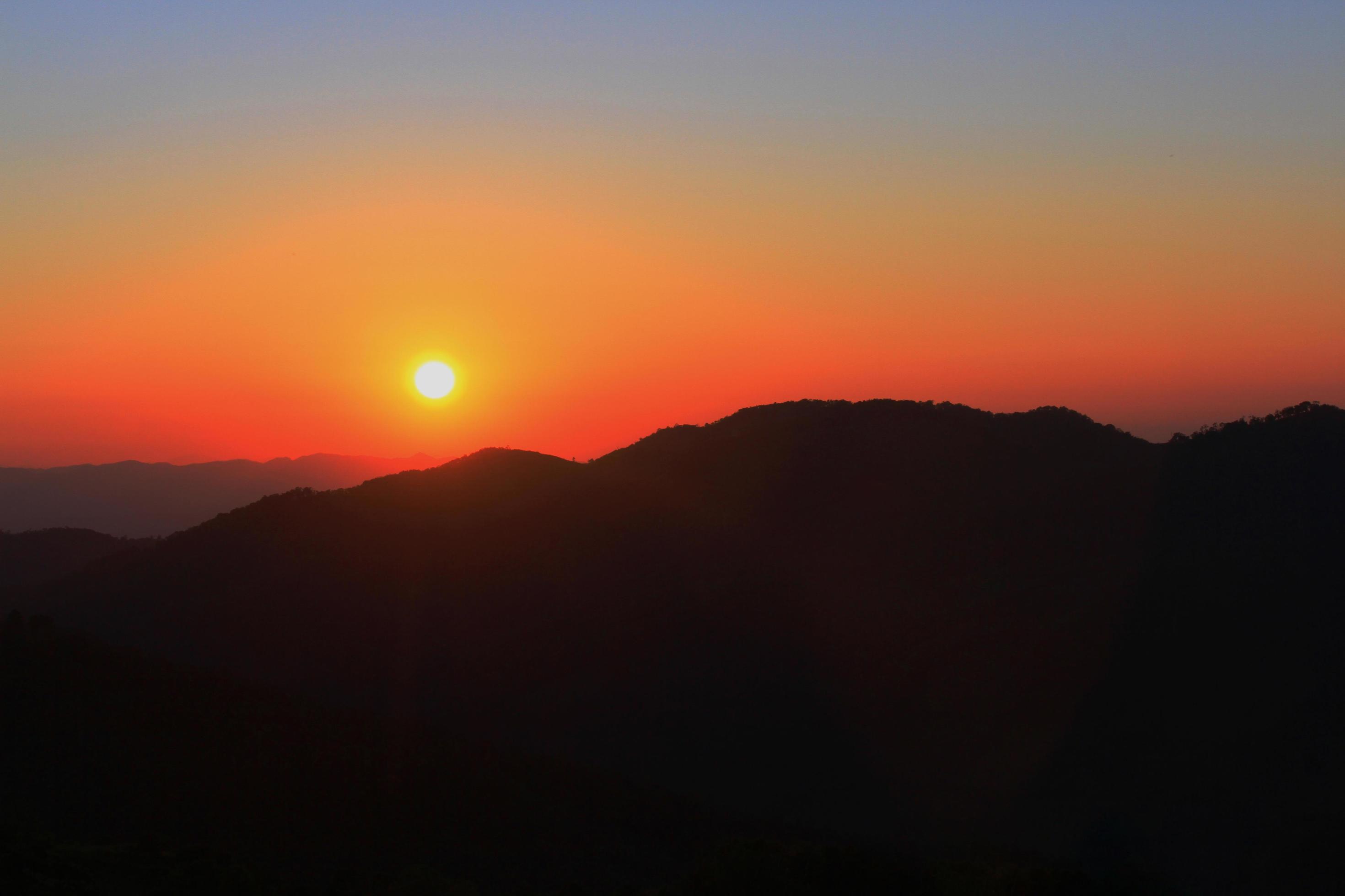 Sunset in sky and cloud, beautiful colorful twilight time with silhouette of mountain. Stock Free