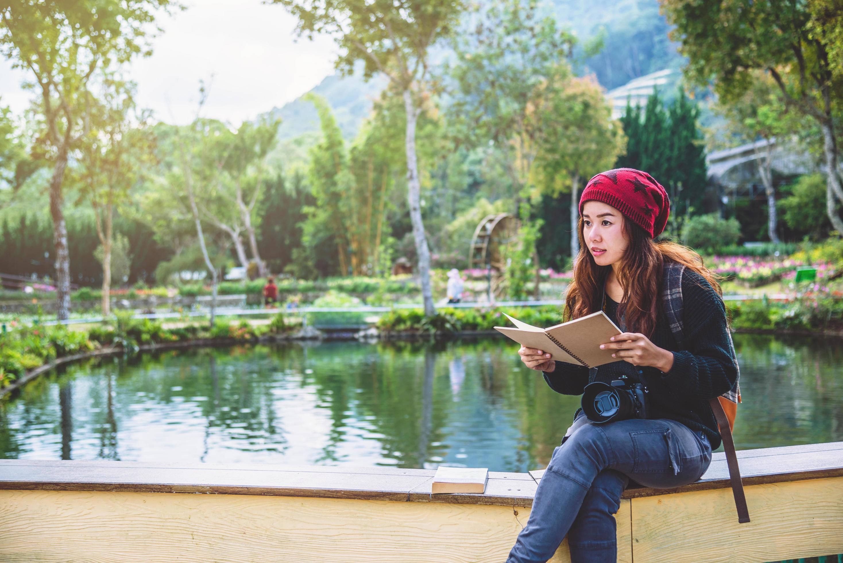 Women travel photograph nature education. nature relax study read a book. at public park in summer. In Thailand Stock Free