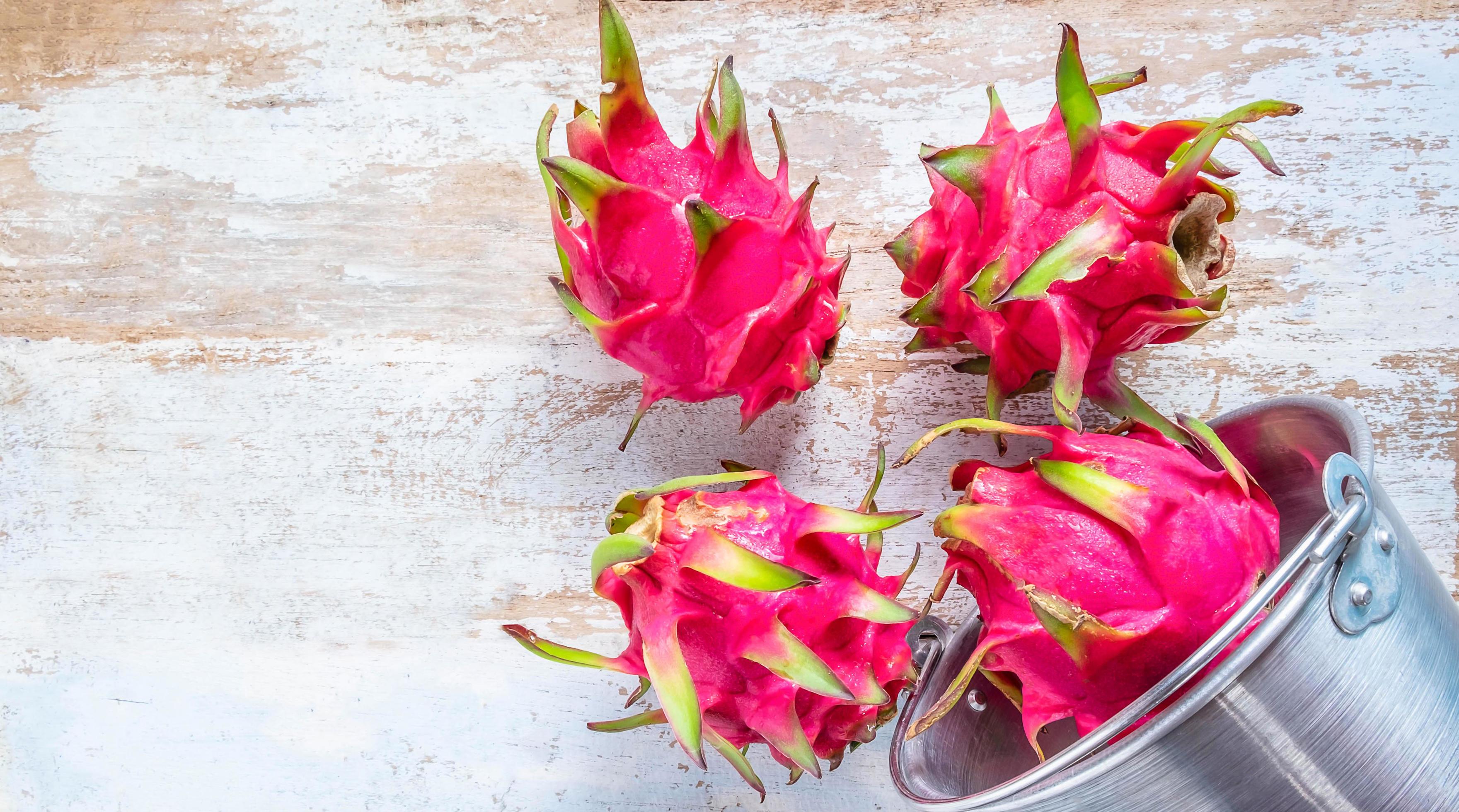 Red dragon fruit of the genus Hylocereus belongs to the family Cactaceae, which is the same family as cactus on wooden background Stock Free