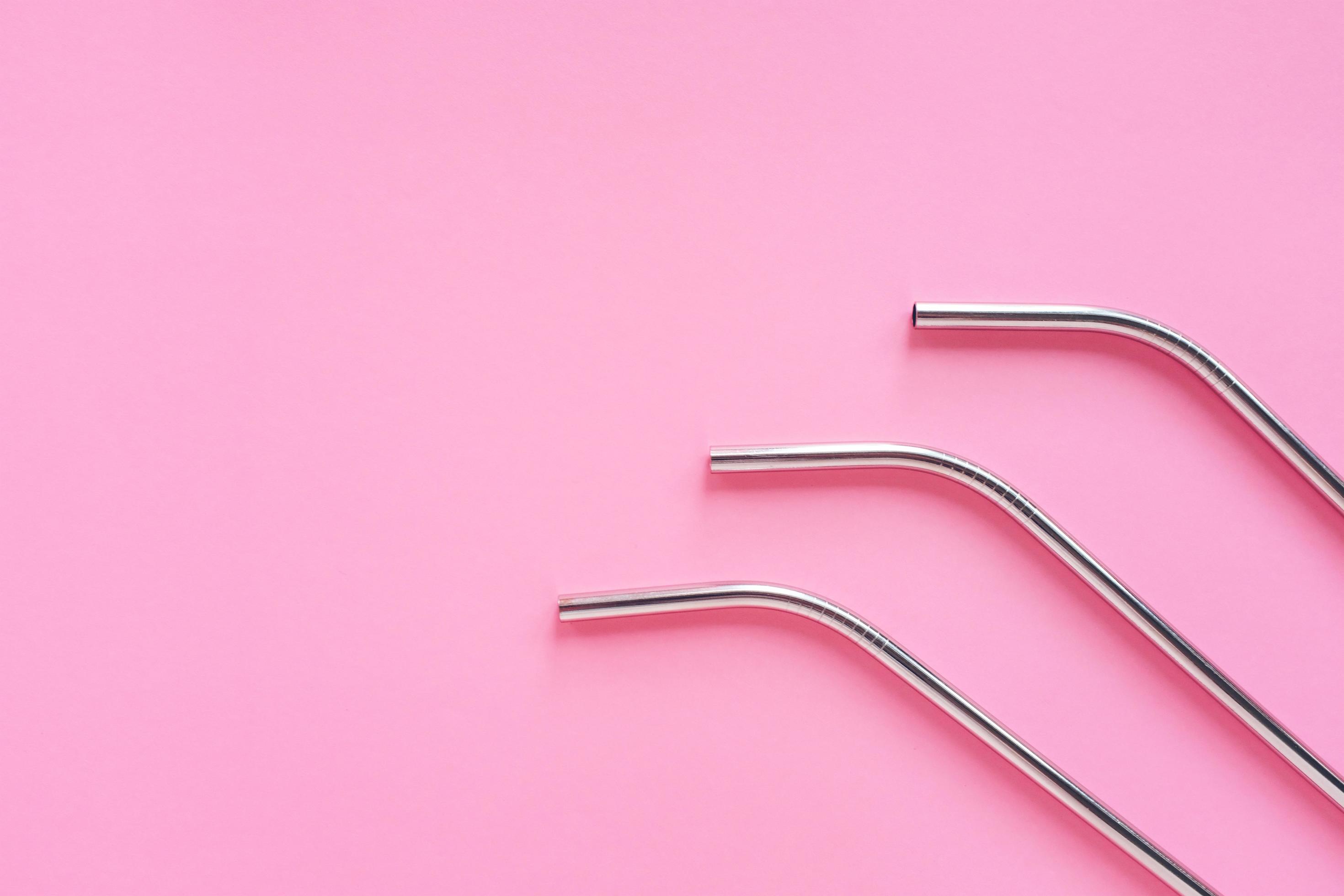 Flat lay of metallic stainless straws for drink on bright pink background, sustainable lifestyle and zero waste concept, copy space Stock Free