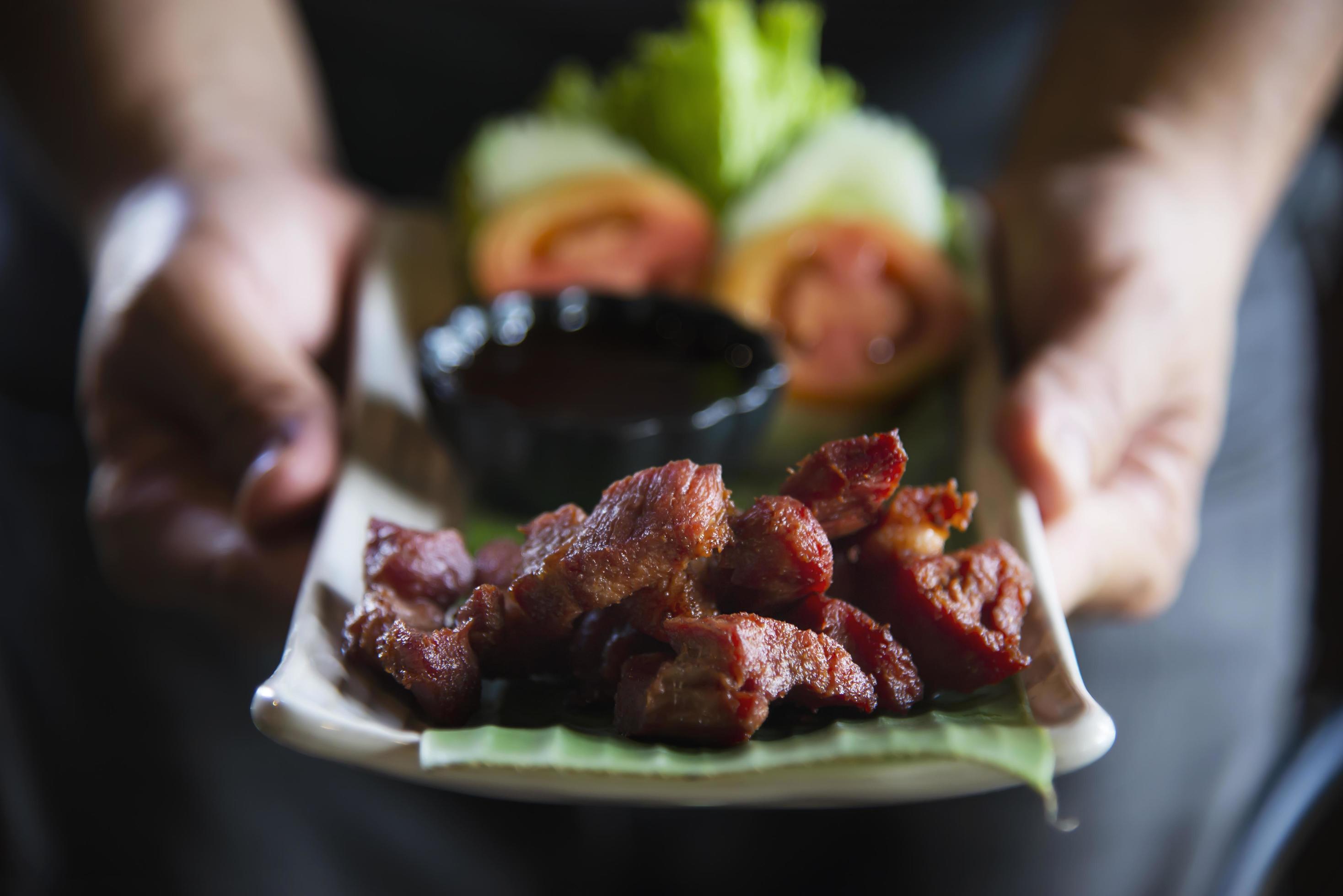 Man serving fried pork recipe – Norther Thai local tradition famous food Stock Free