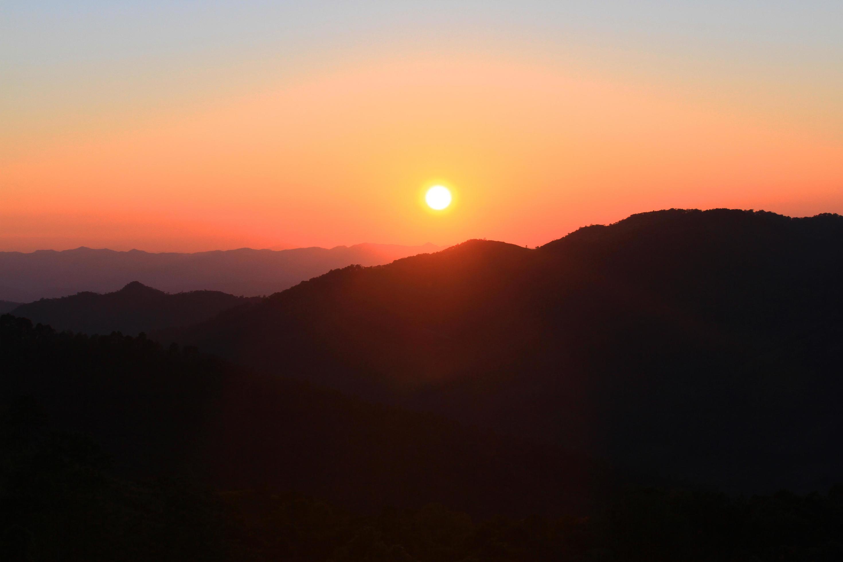 Sunset in sky and cloud, beautiful colorful twilight time with silhouette of mountain. Stock Free