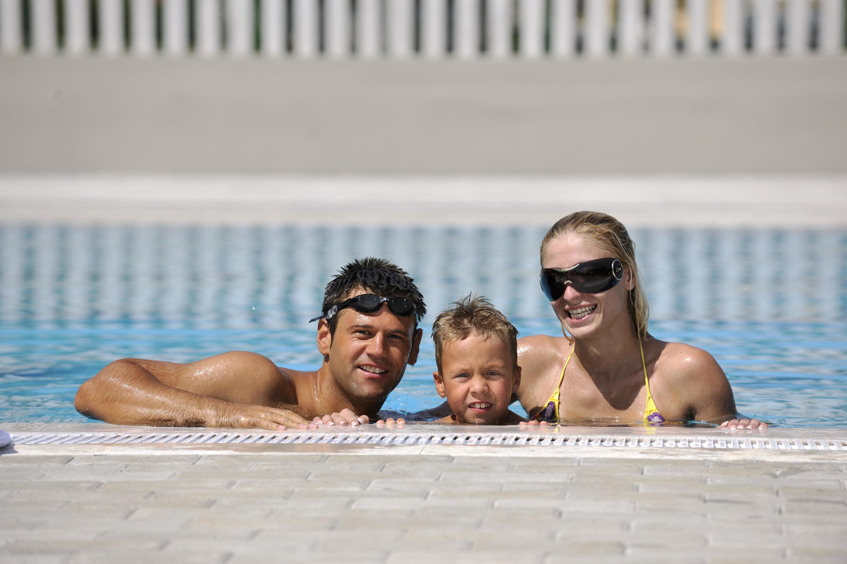 happy young family have fun on swimming pool Stock Free