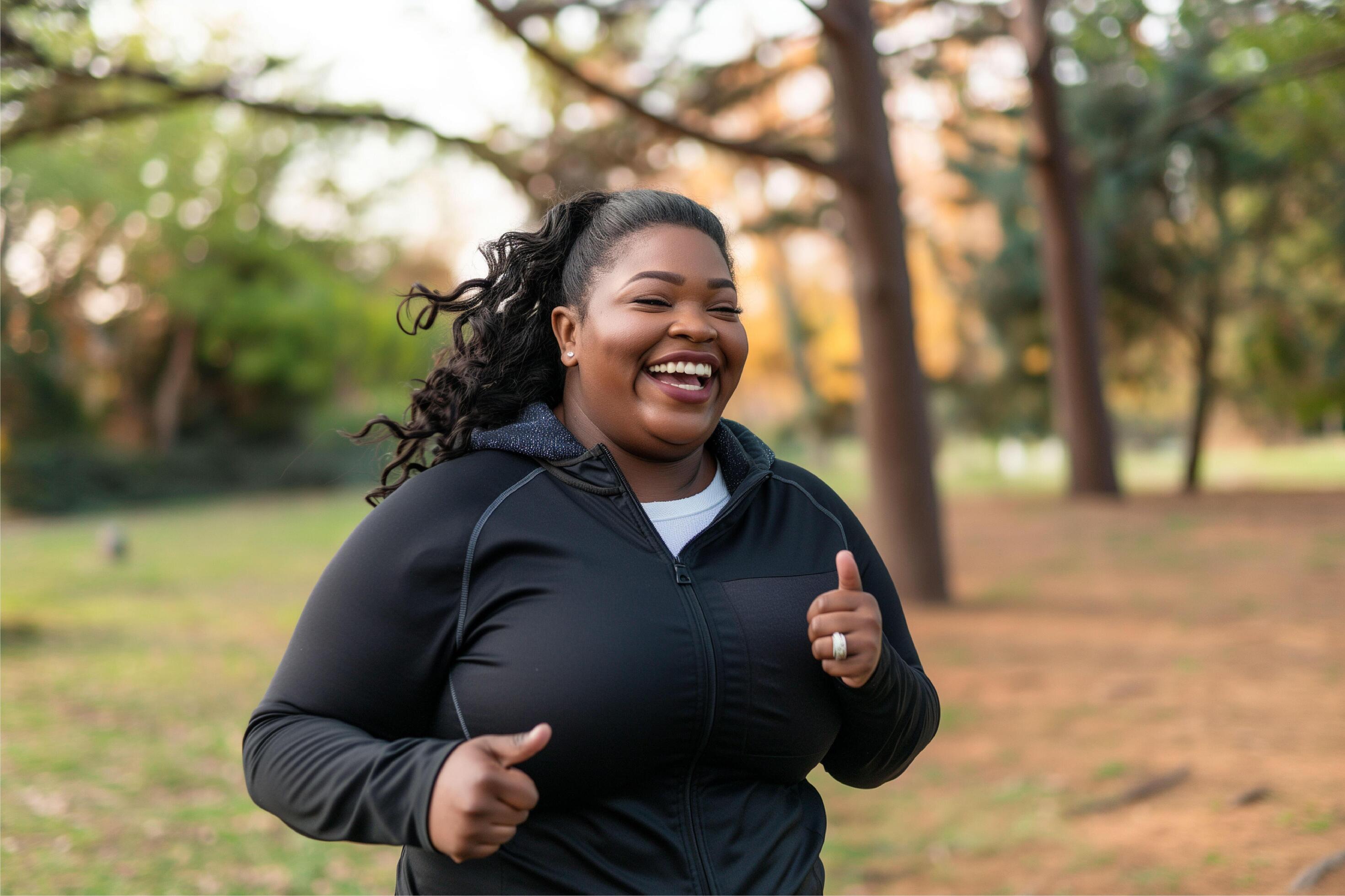 Happy plus size black woman jogging outdoors Stock Free