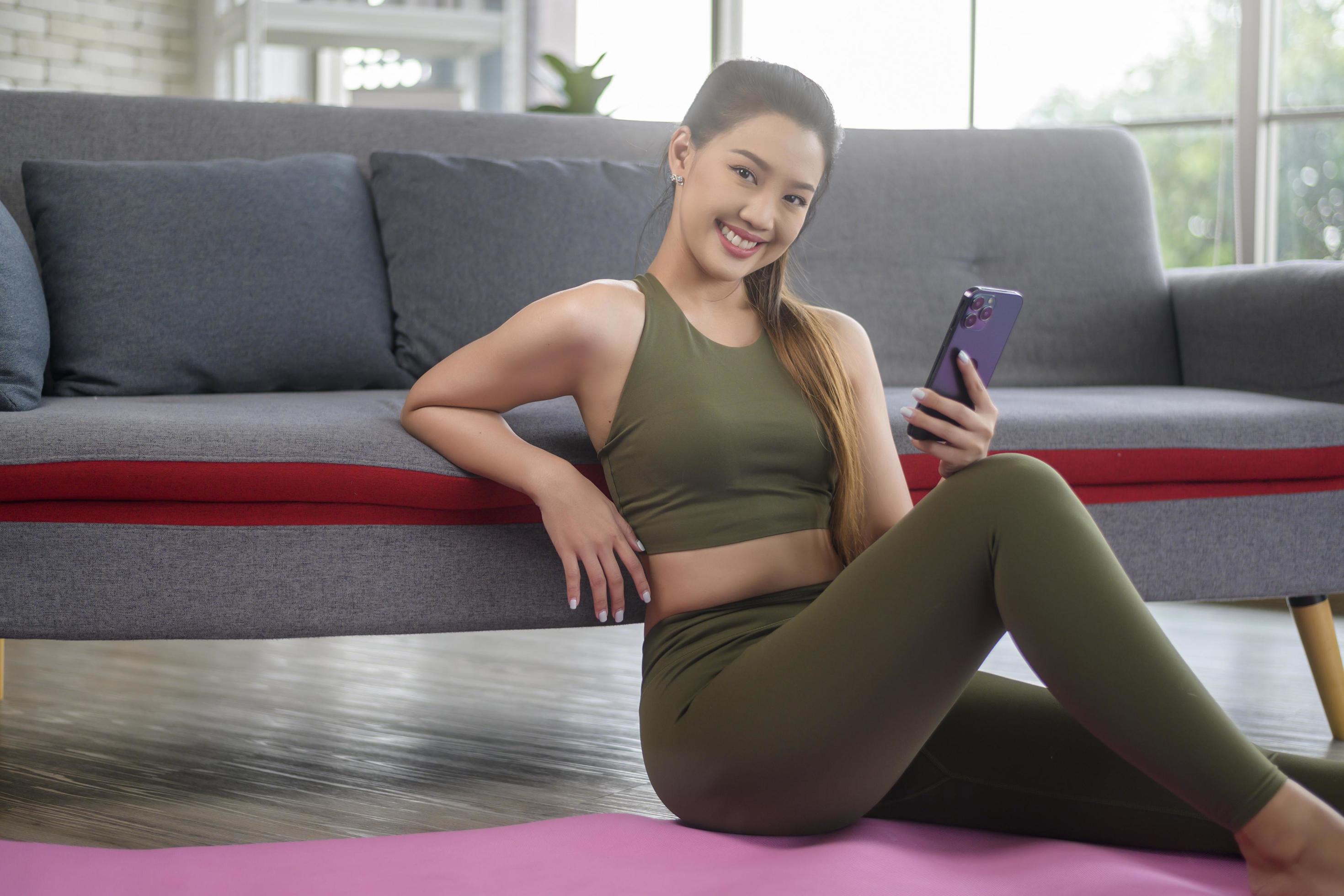 Young fitness woman in sportswear using smart phone while exercising at home, Healthy and Lifestyles. Stock Free