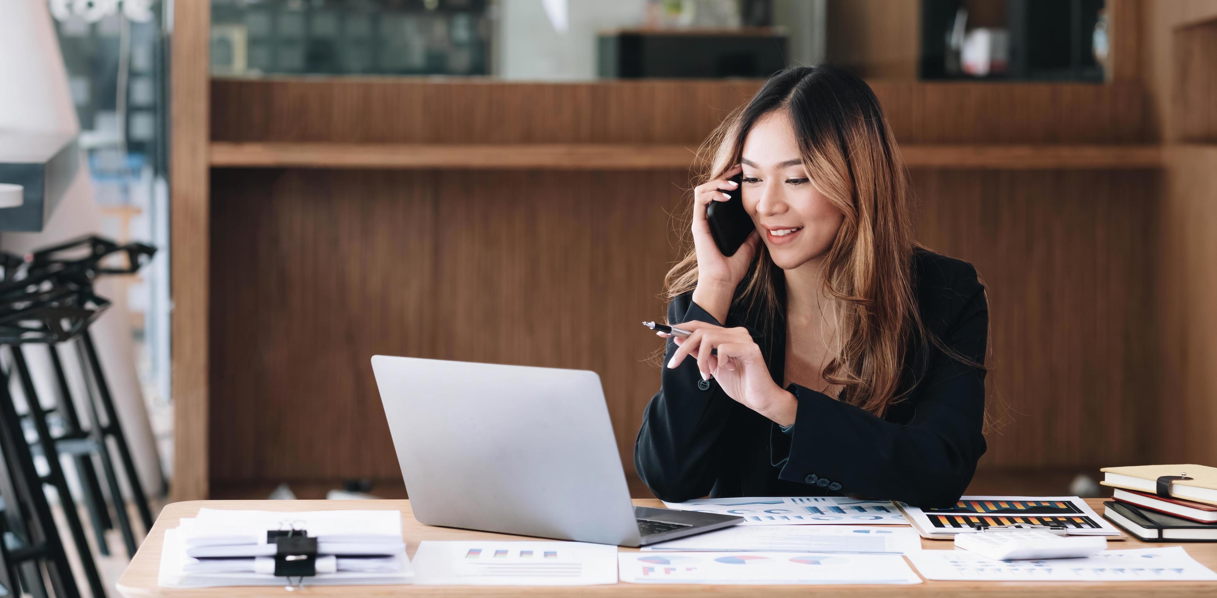 Asian business woman have the joy of talking on the phone, laptop and tablet on the office desk. Stock Free