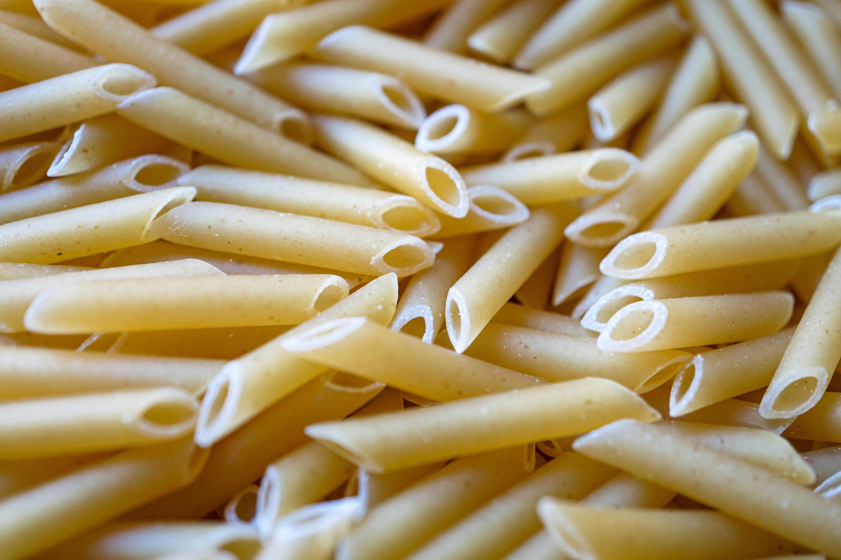 uncooked macaroni pasta background, italian food Stock Free