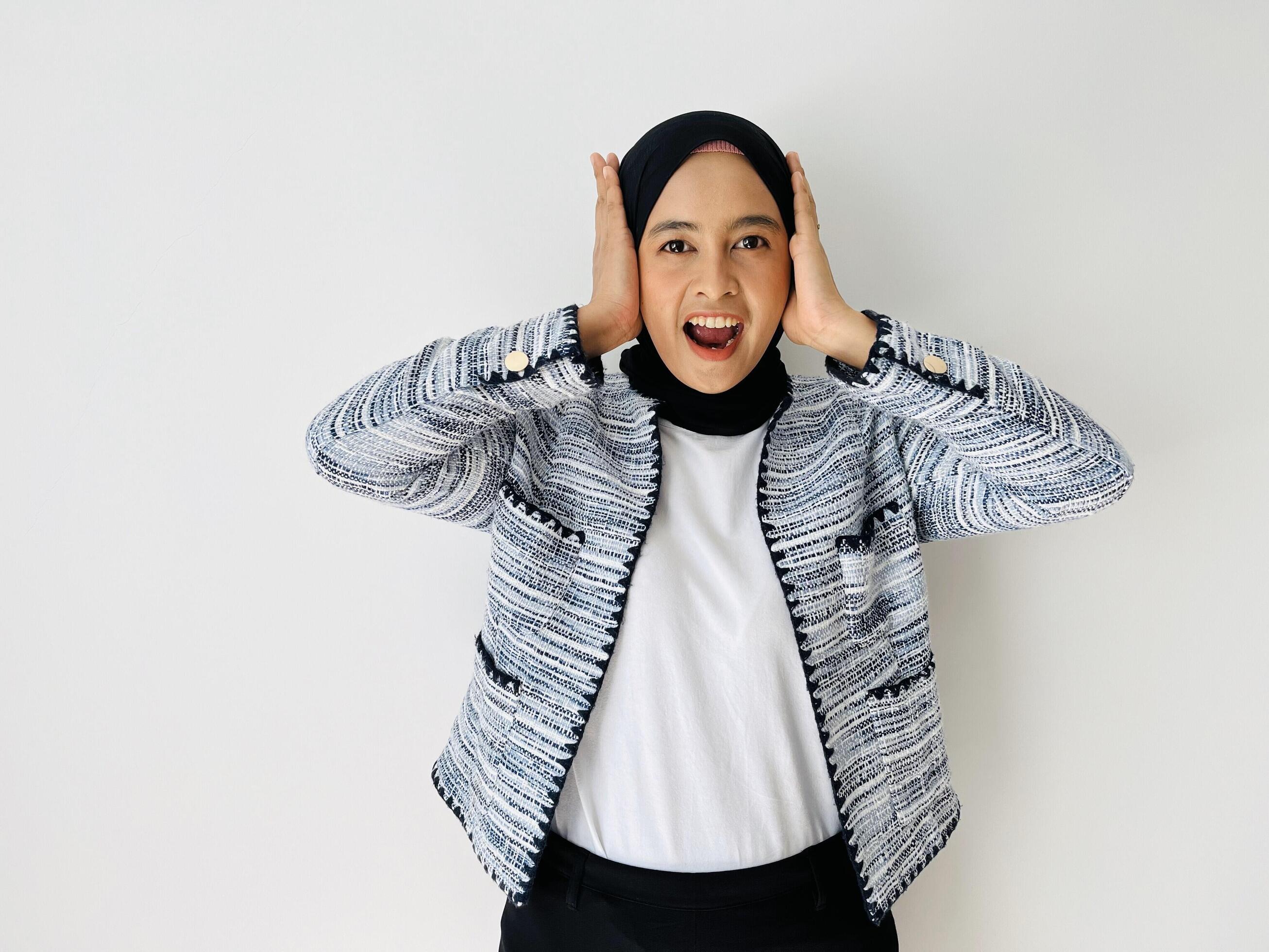 Portrait of amazed impressed Asian young woman wear headscarves and blazers with arms head open mouth isolated white background Stock Free