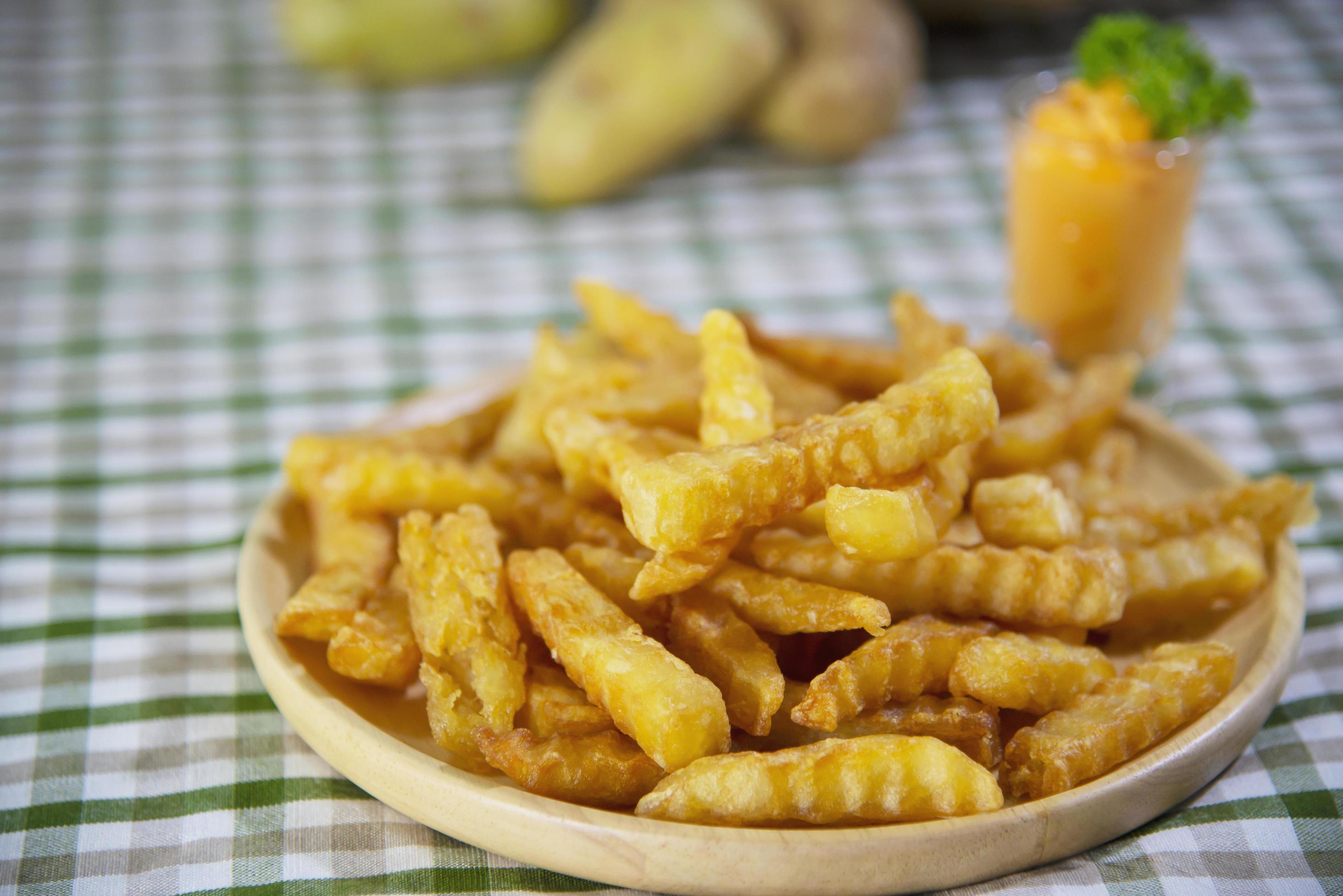 Delicious fried potato on wooden plate with dipped sauce – traditional fast food concept Stock Free