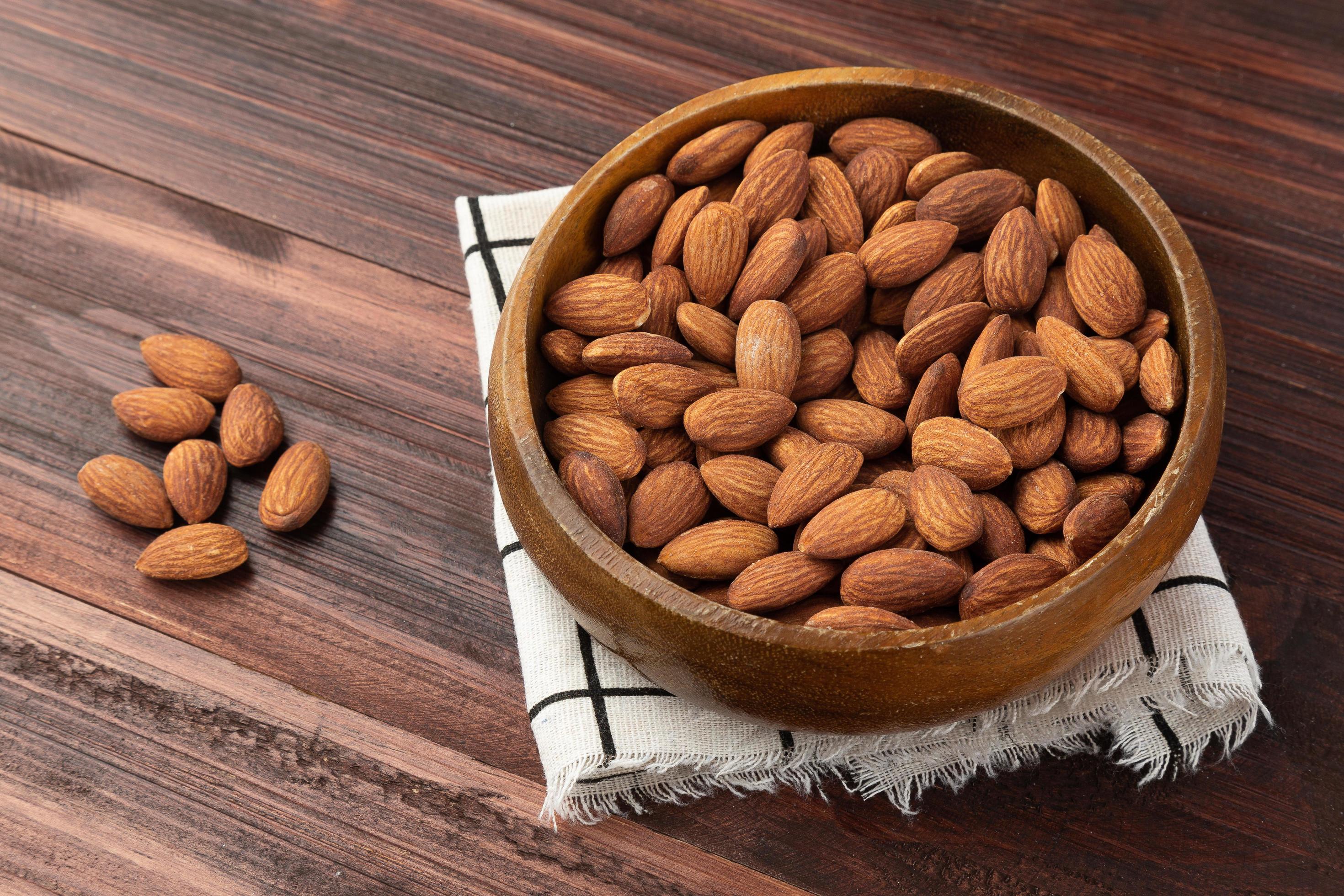 Almonds in wooden bowl on the table, Healthy snack, Vegetarian food Stock Free