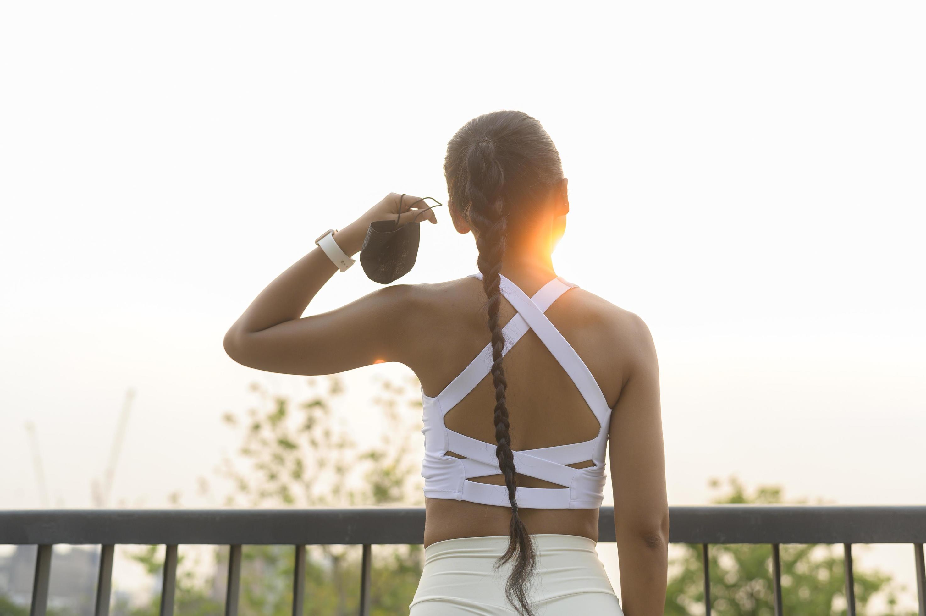 Young fitness woman in sportswear taking face mask off while exercise in city park, Health and Lifestyles. Stock Free