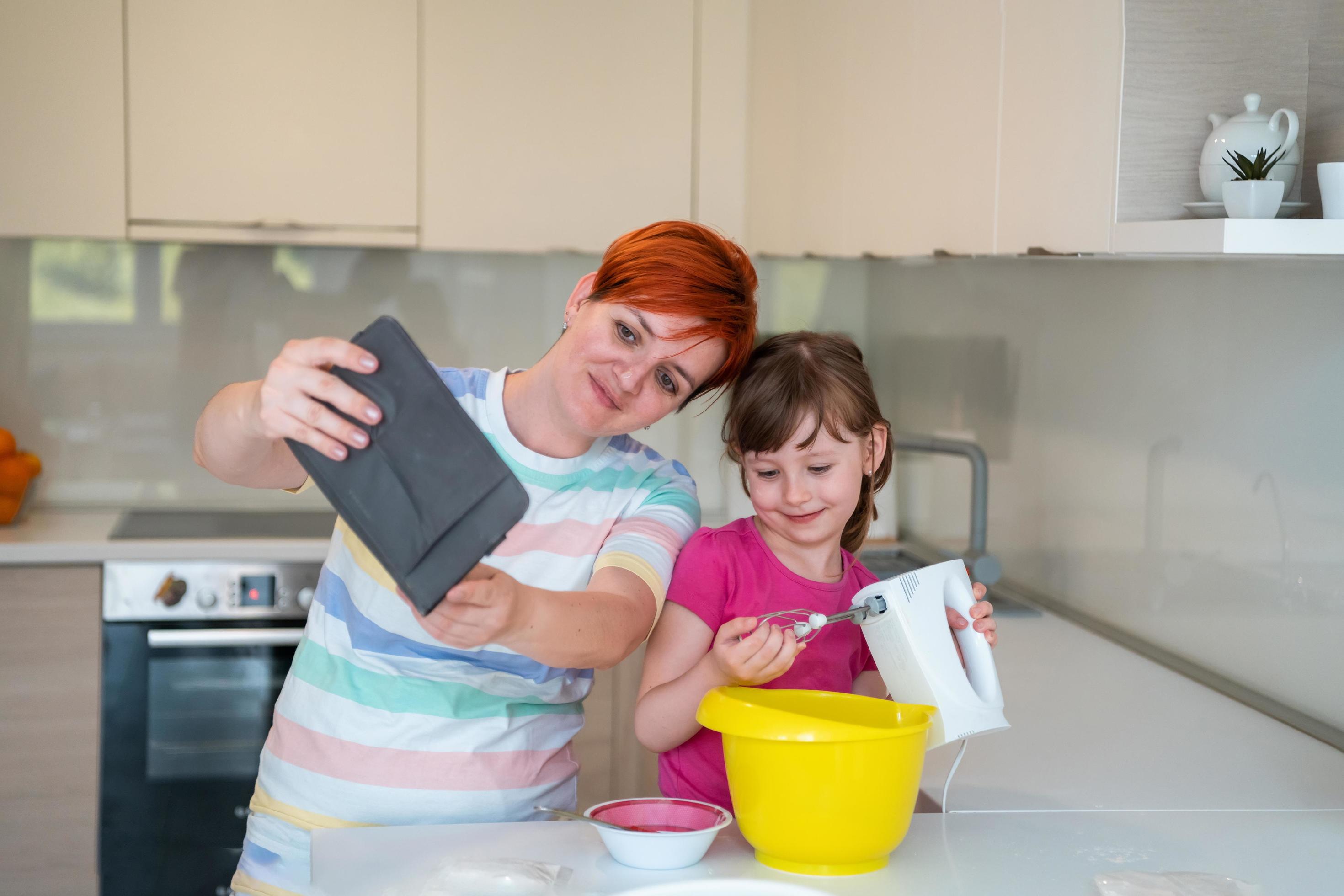 little girl and mom making tastz cake in kithen family having fun at home Stock Free