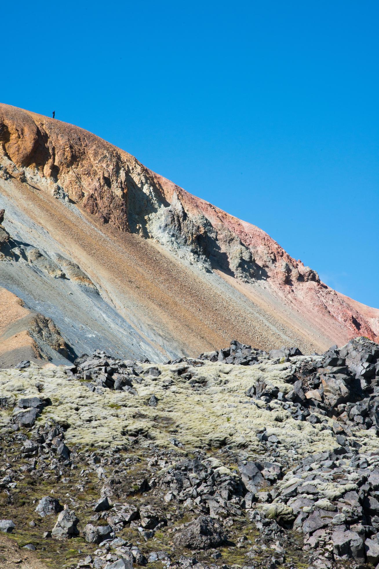 Colorful mountain with a person on top Stock Free