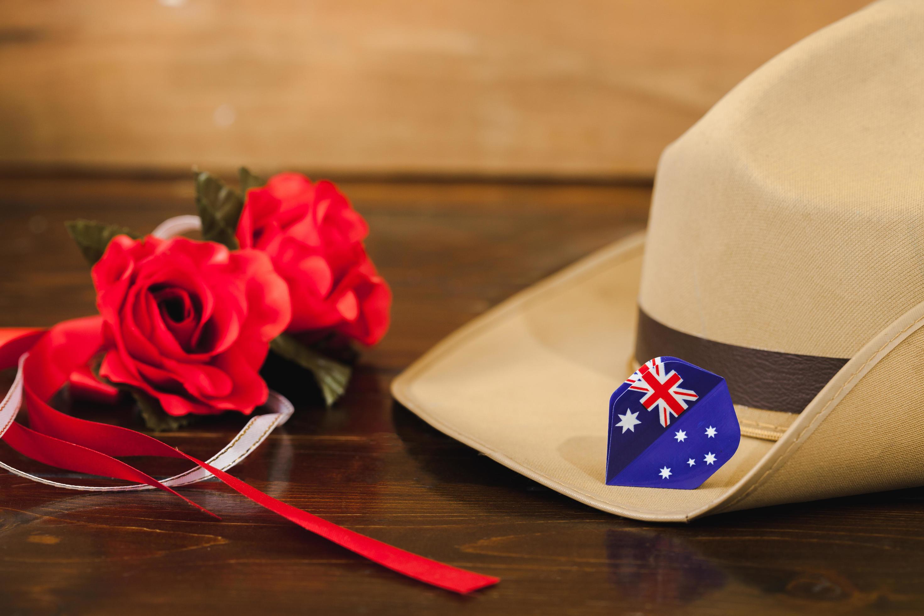 Anzac army slouch hat with red flower on vintage wood background . Stock Free