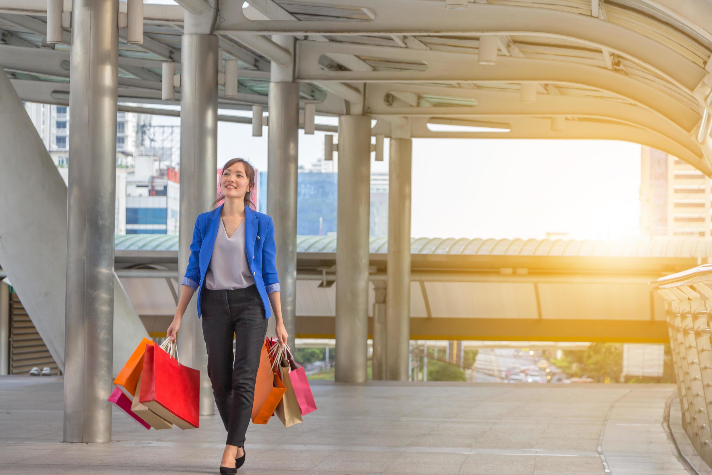 young woman carrying shopping bags while walking along the street. Happy Life Style Concept. Stock Free