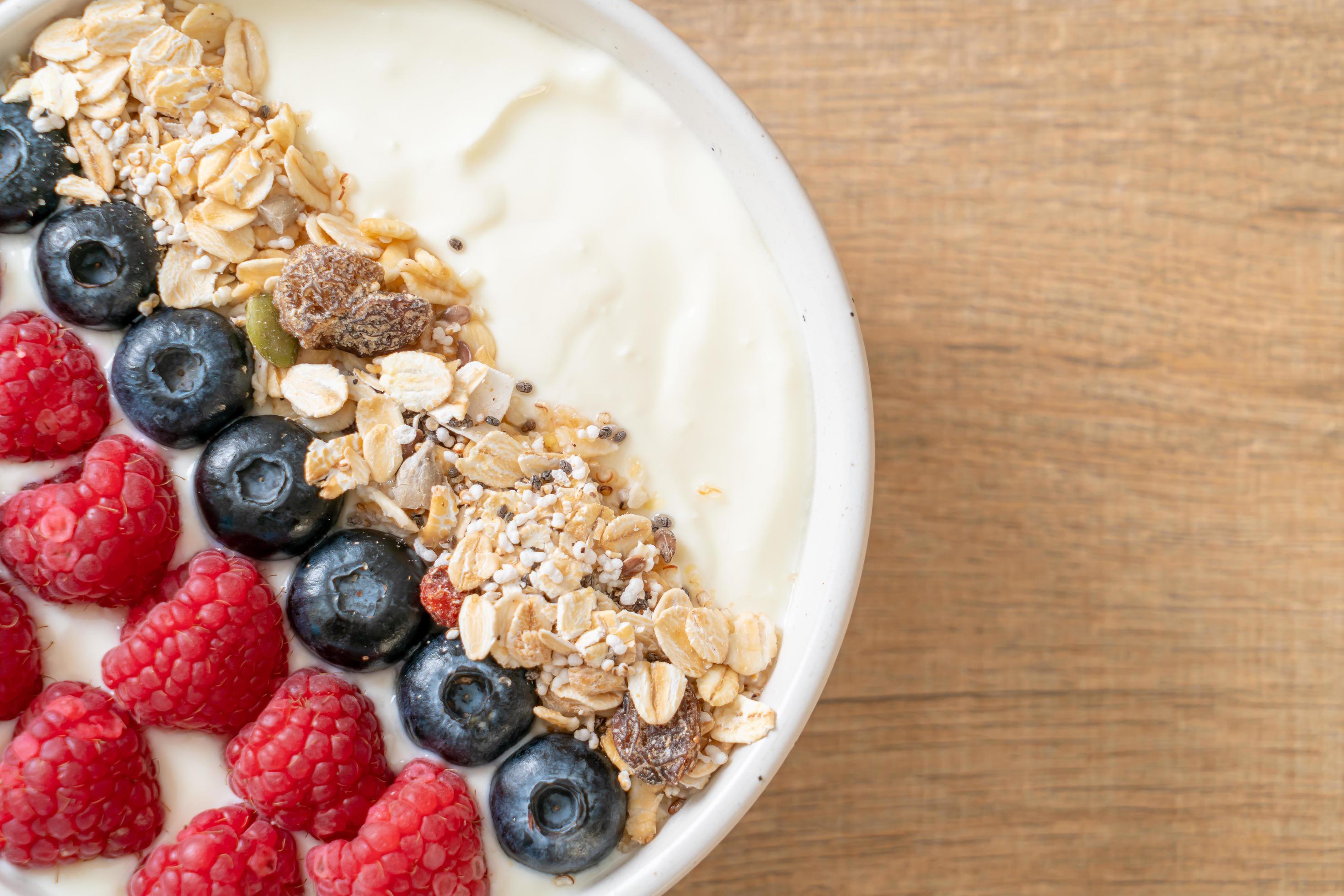 Homemade yogurt bowl with raspberry, blueberry and granola – healthy food style Stock Free