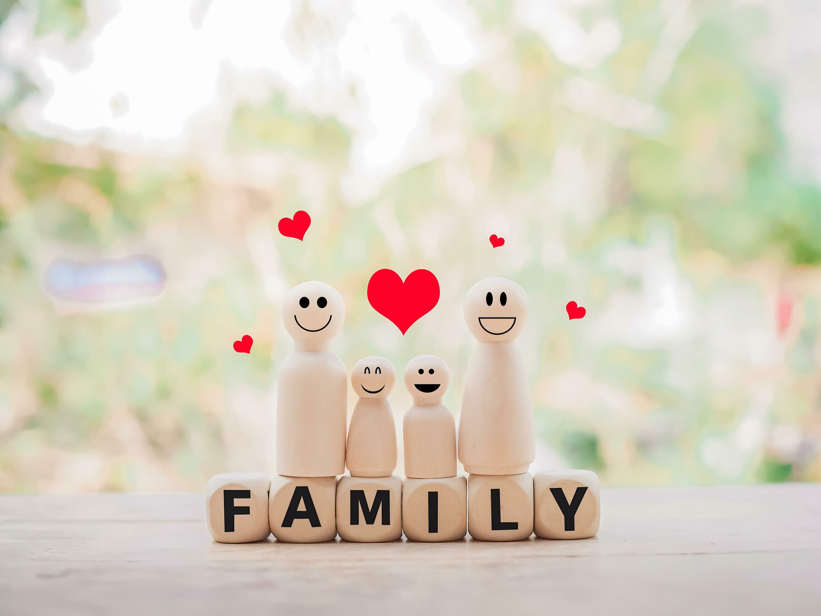 Wooden figure of the family standing on wooden blocks with the word FAMILY for happy family concept Stock Free