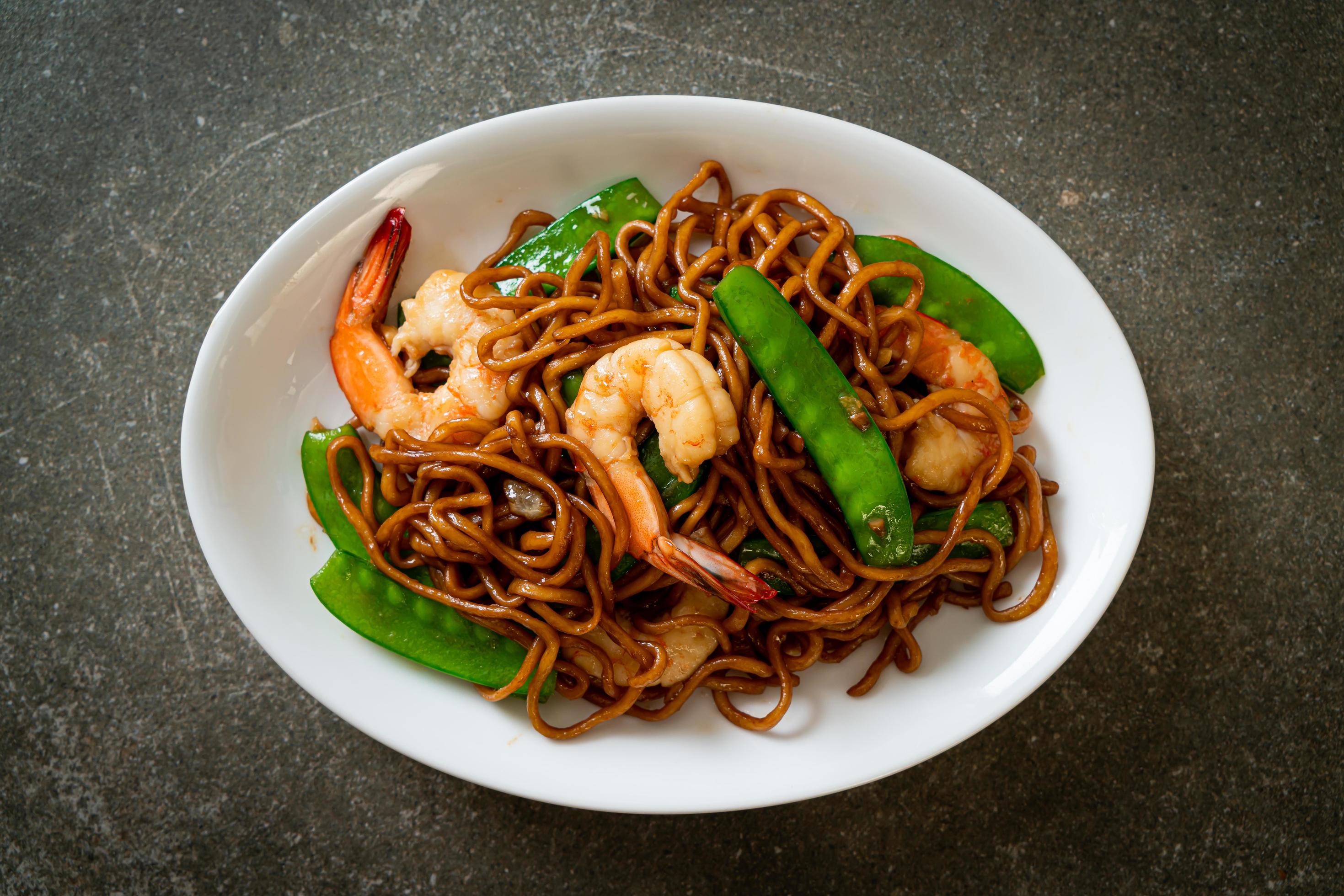 Stir-fried yakisoba noodles with green peas and shrimps – Asian food style Stock Free