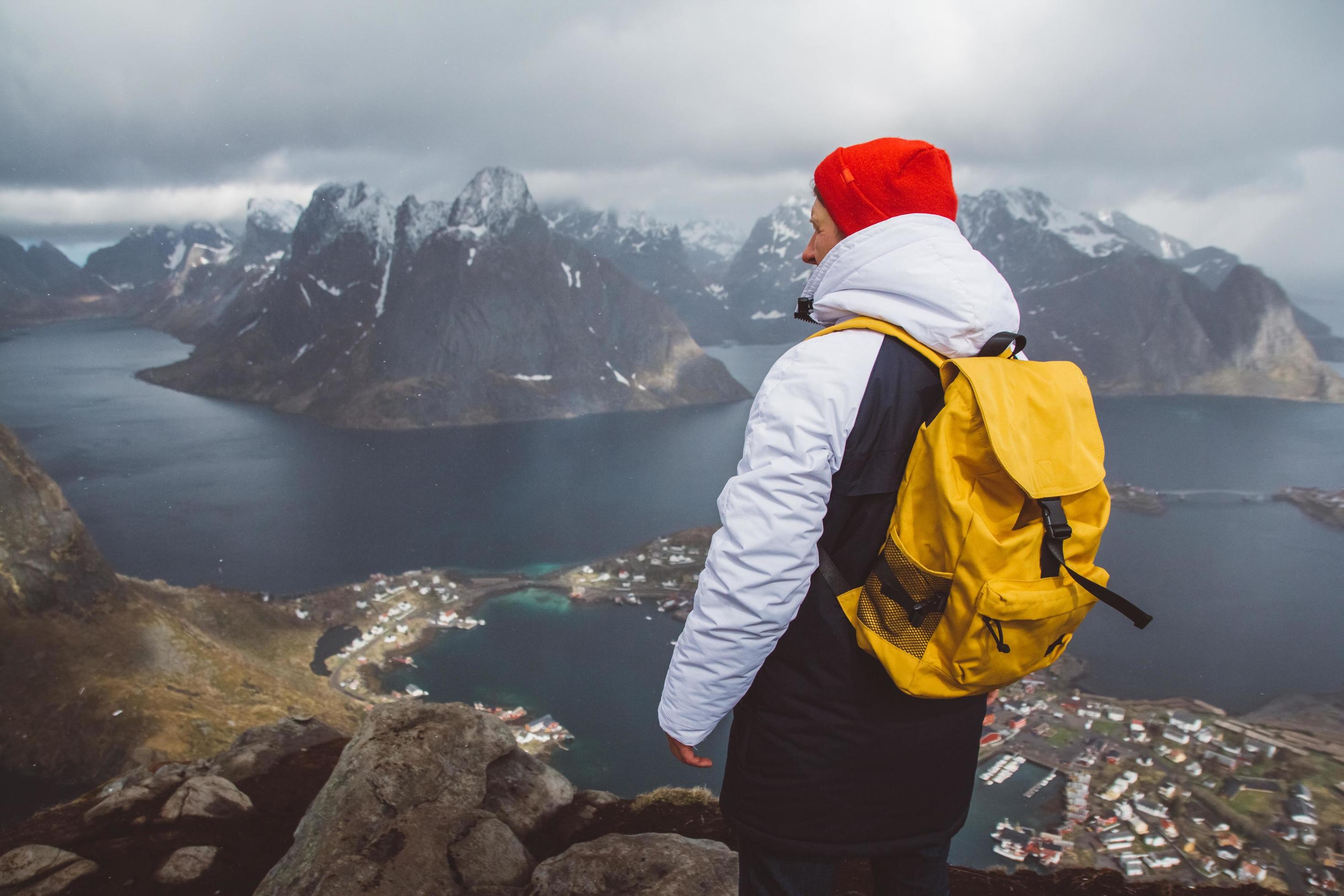 Man traveler hiking on Reinebringen mountain ridge in Norway lifestyle adventure traveling Stock Free