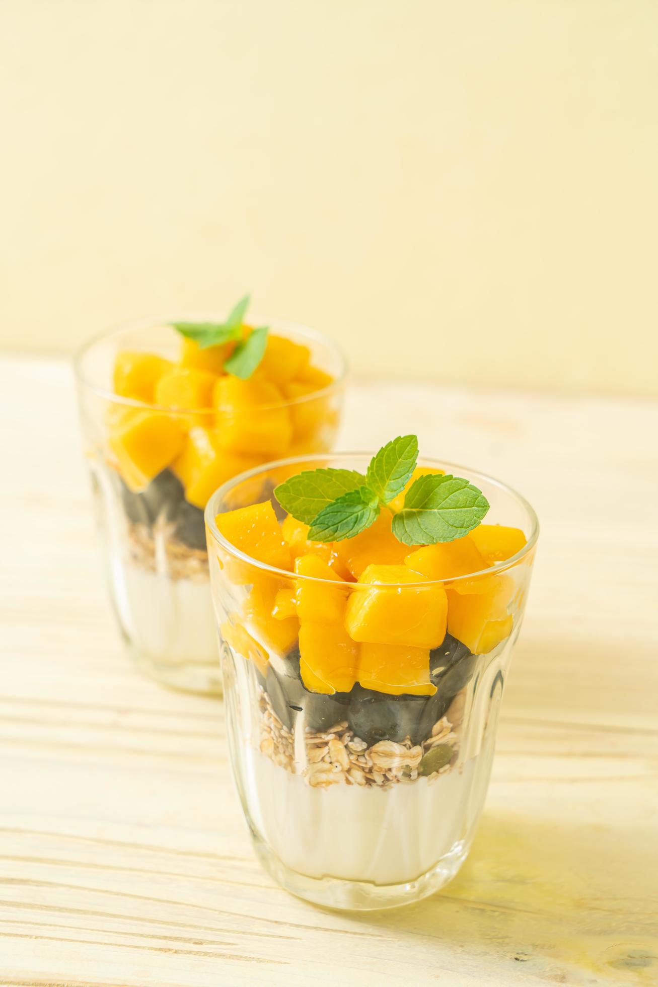 Homemade fresh mango and fresh blueberry with yogurt and granola – healthy food style Stock Free