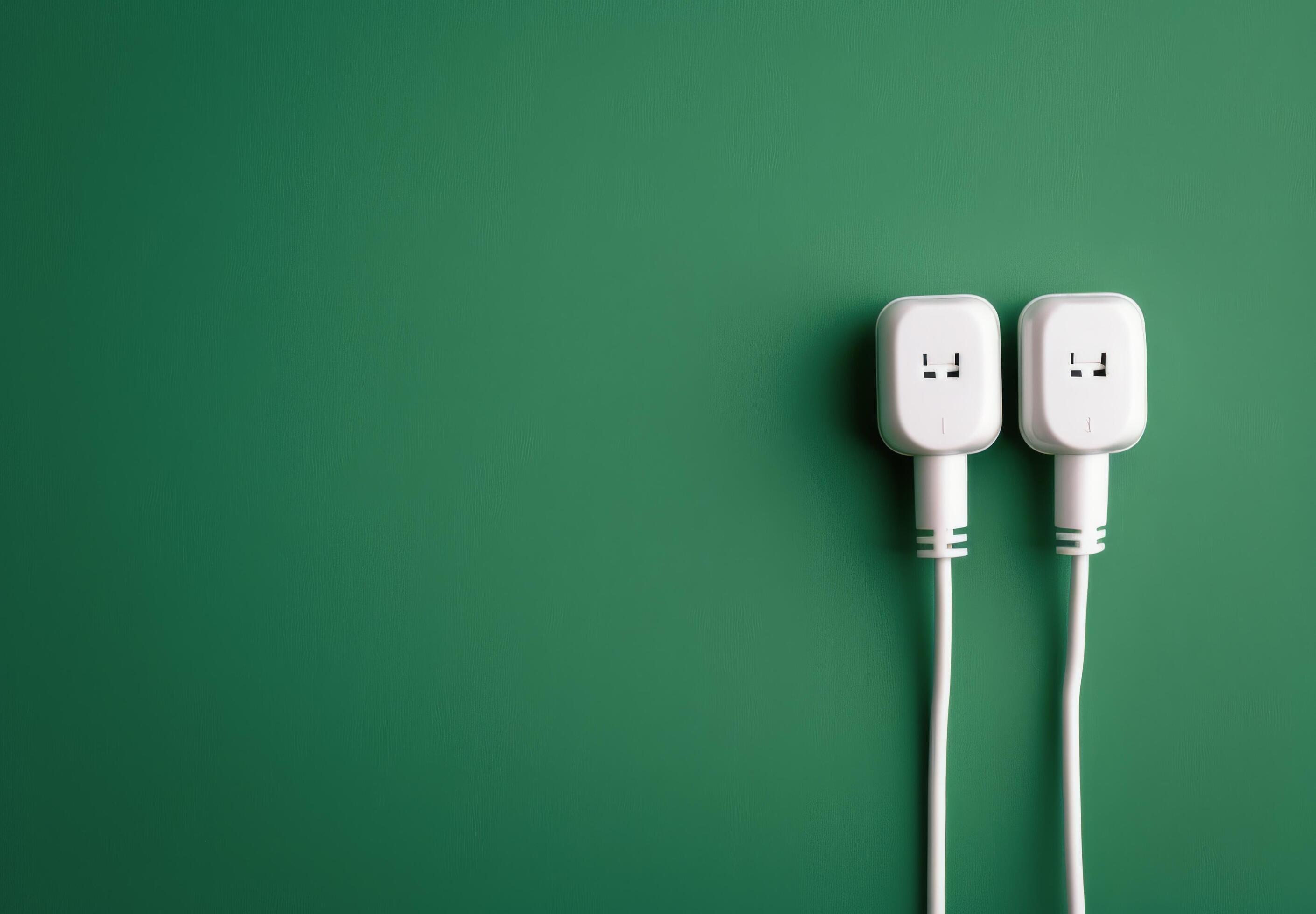 Two White Electrical Plugs on Green Background Stock Free