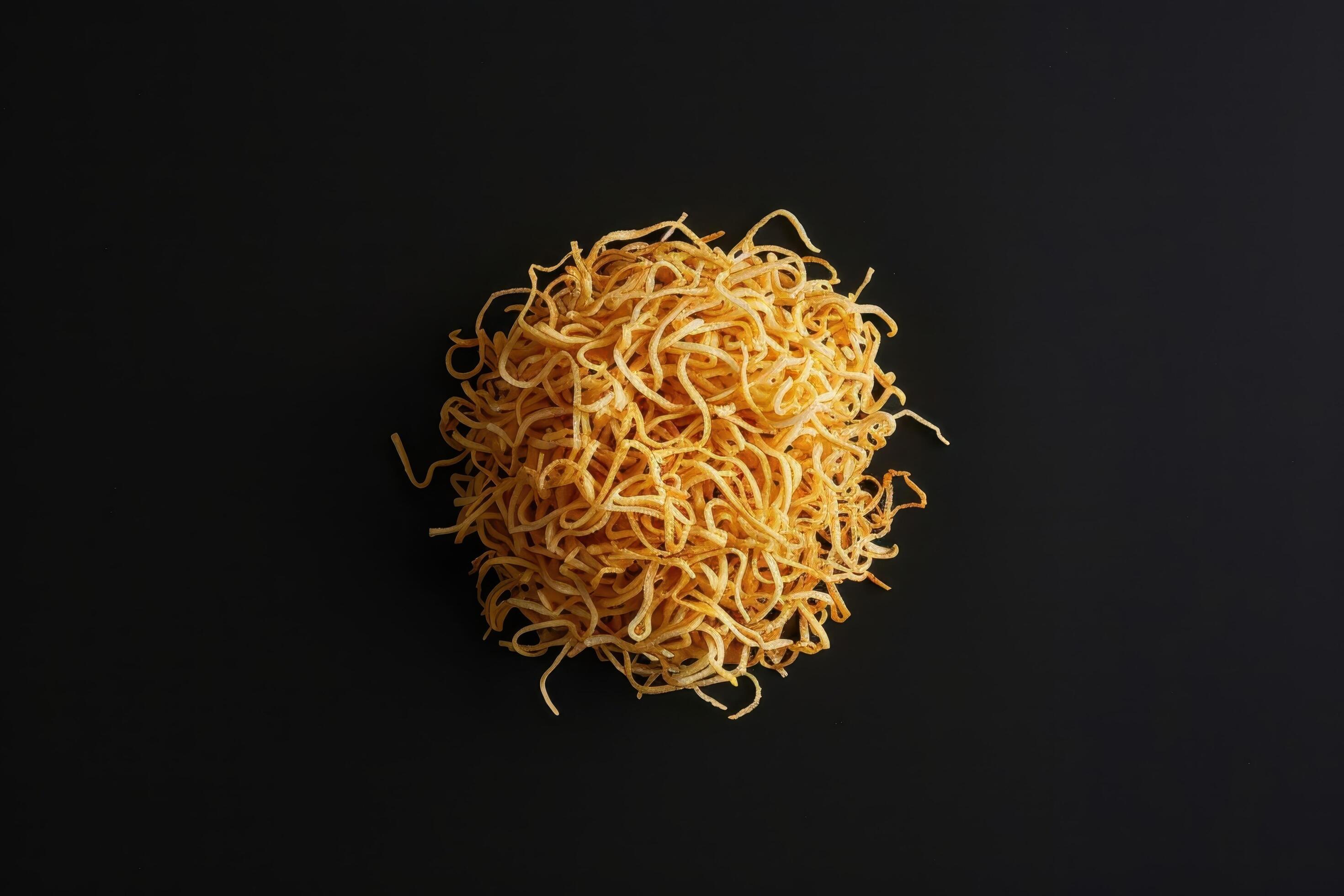 A Pile of Crispy Golden Fried Noodles on a Black Background Stock Free