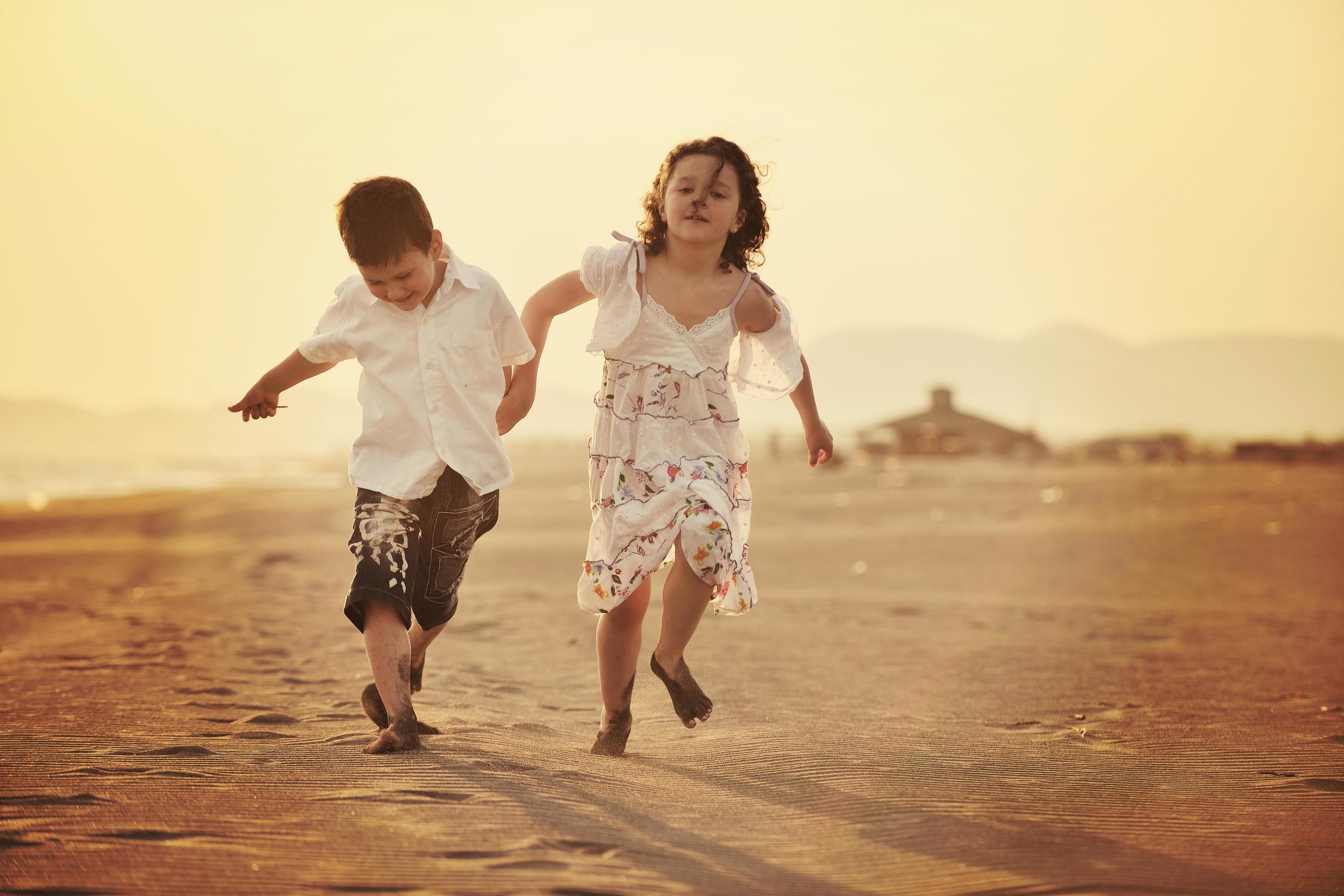 happy young family have fun on beach at sunset Stock Free