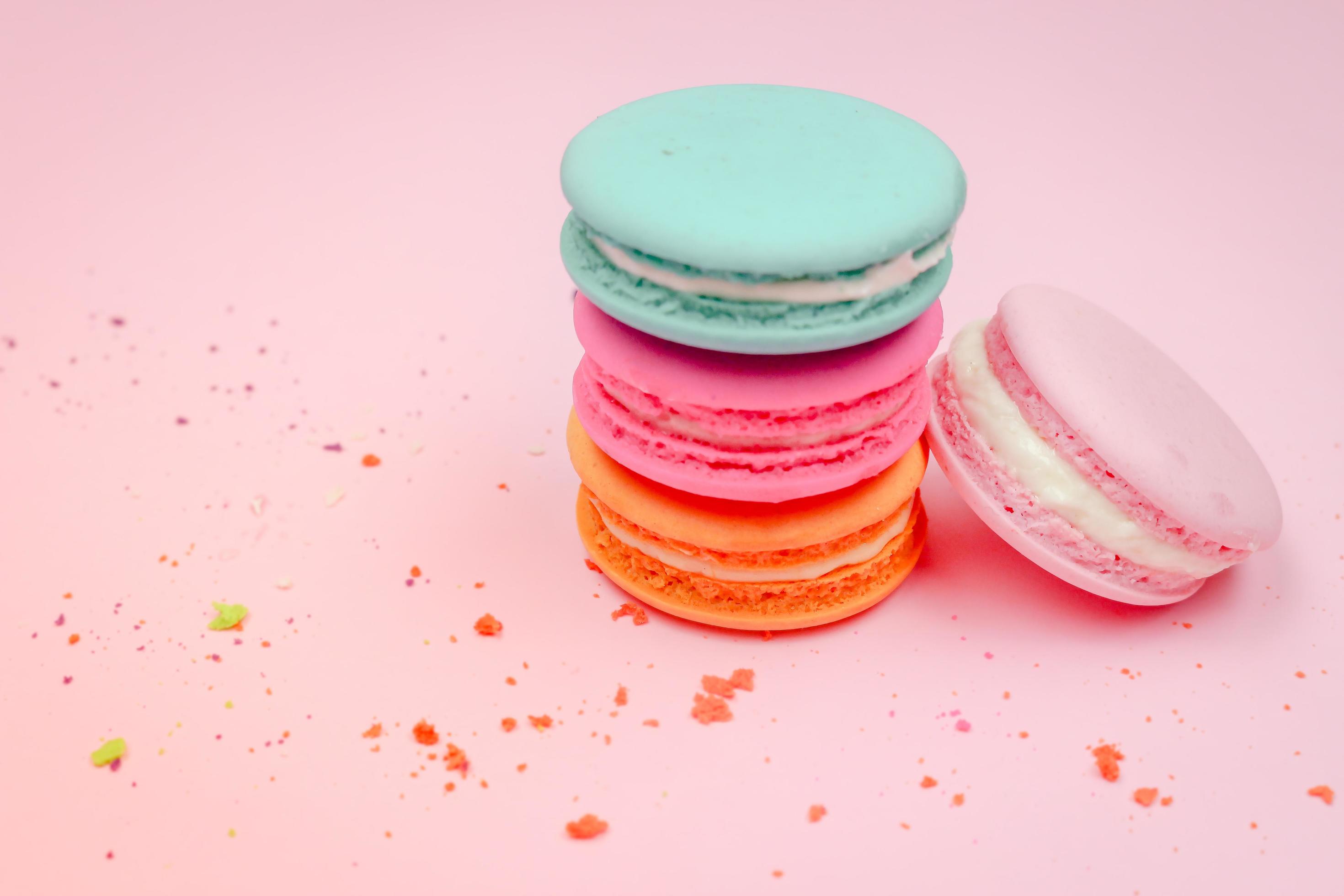 Colorful french macarons macaroons cake, delicious sweet dessert on a pink background with copyspace, food background concept. Stock Free