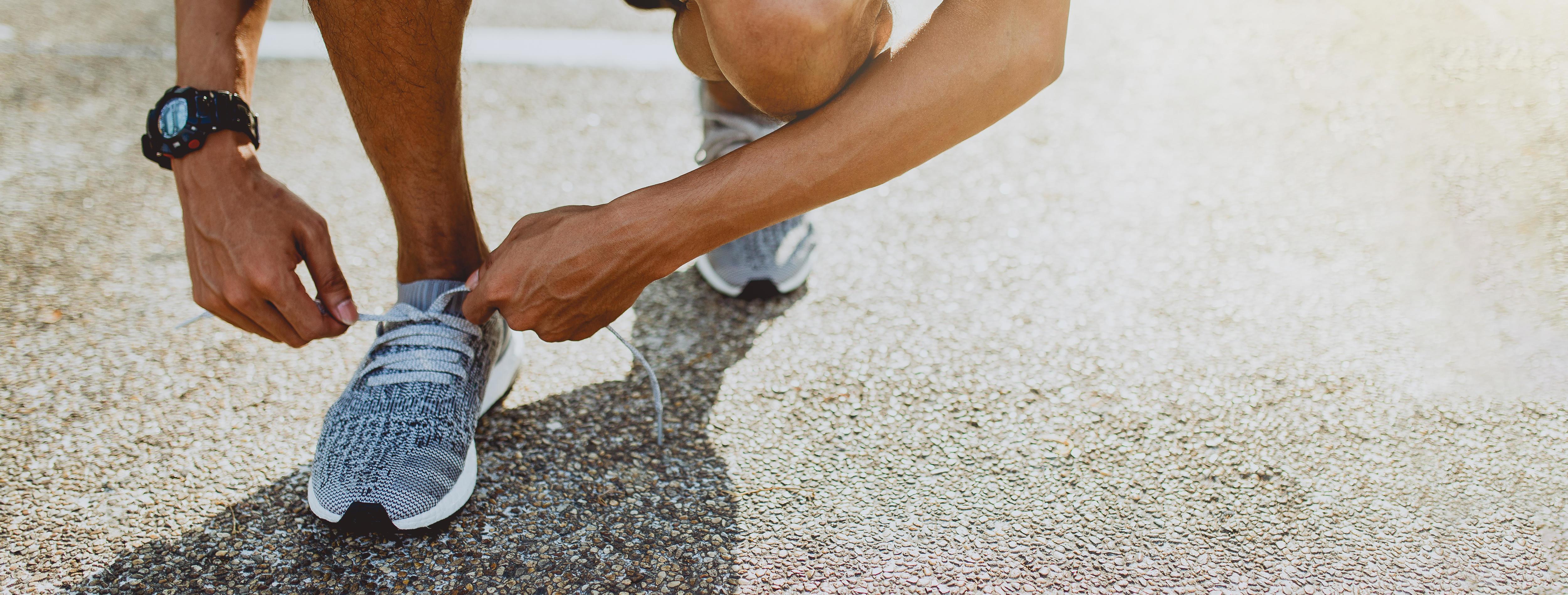 Man tying running shoes getting ready for run. Healthy lifestyle and sport. Banner with copy space. Stock Free