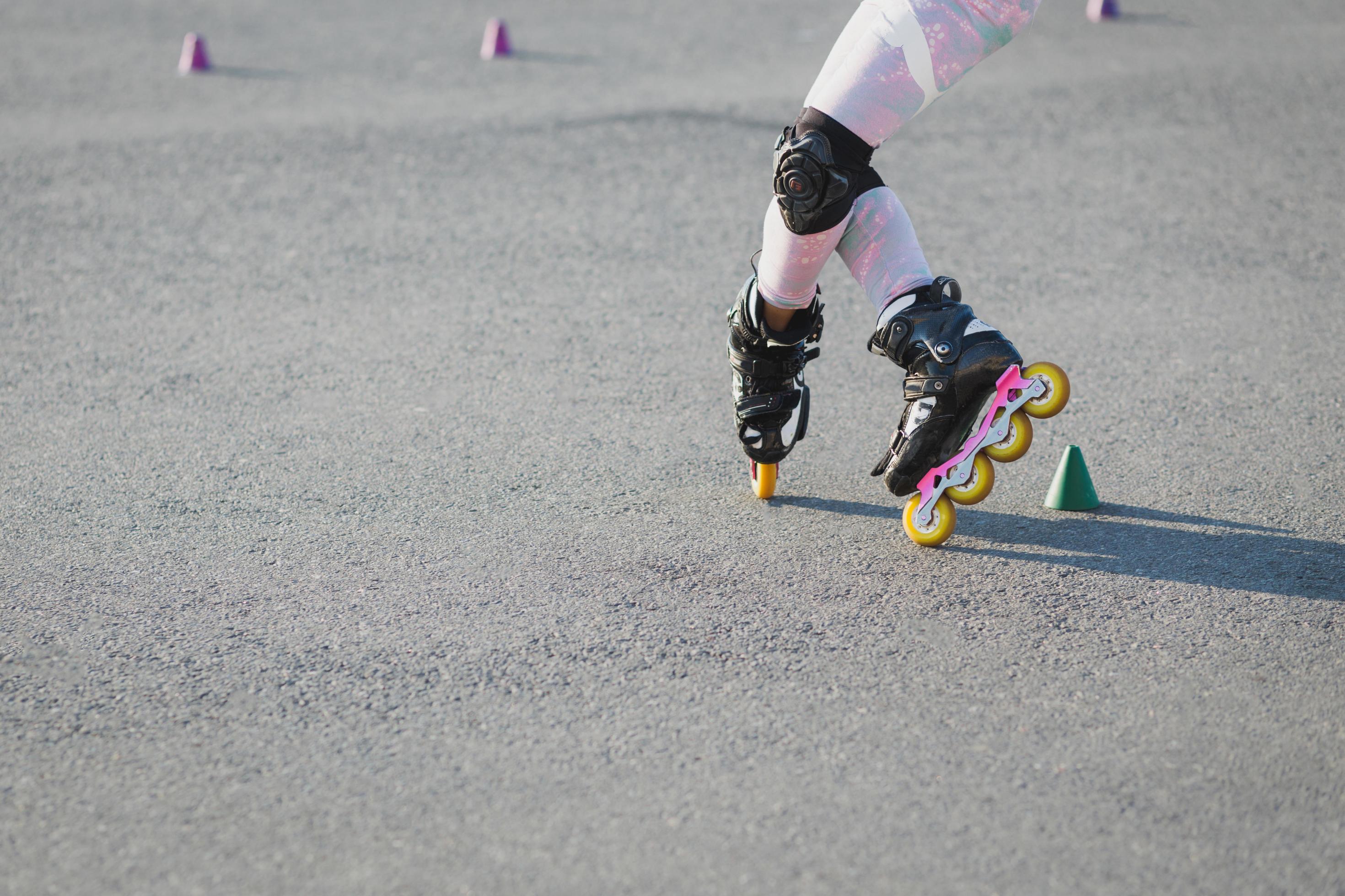 Cropped shot of teenager rollerblades on asphalt, has trial, wears rollerblade and protection on knees. Active lifestyle, leisure and hobby concept Stock Free