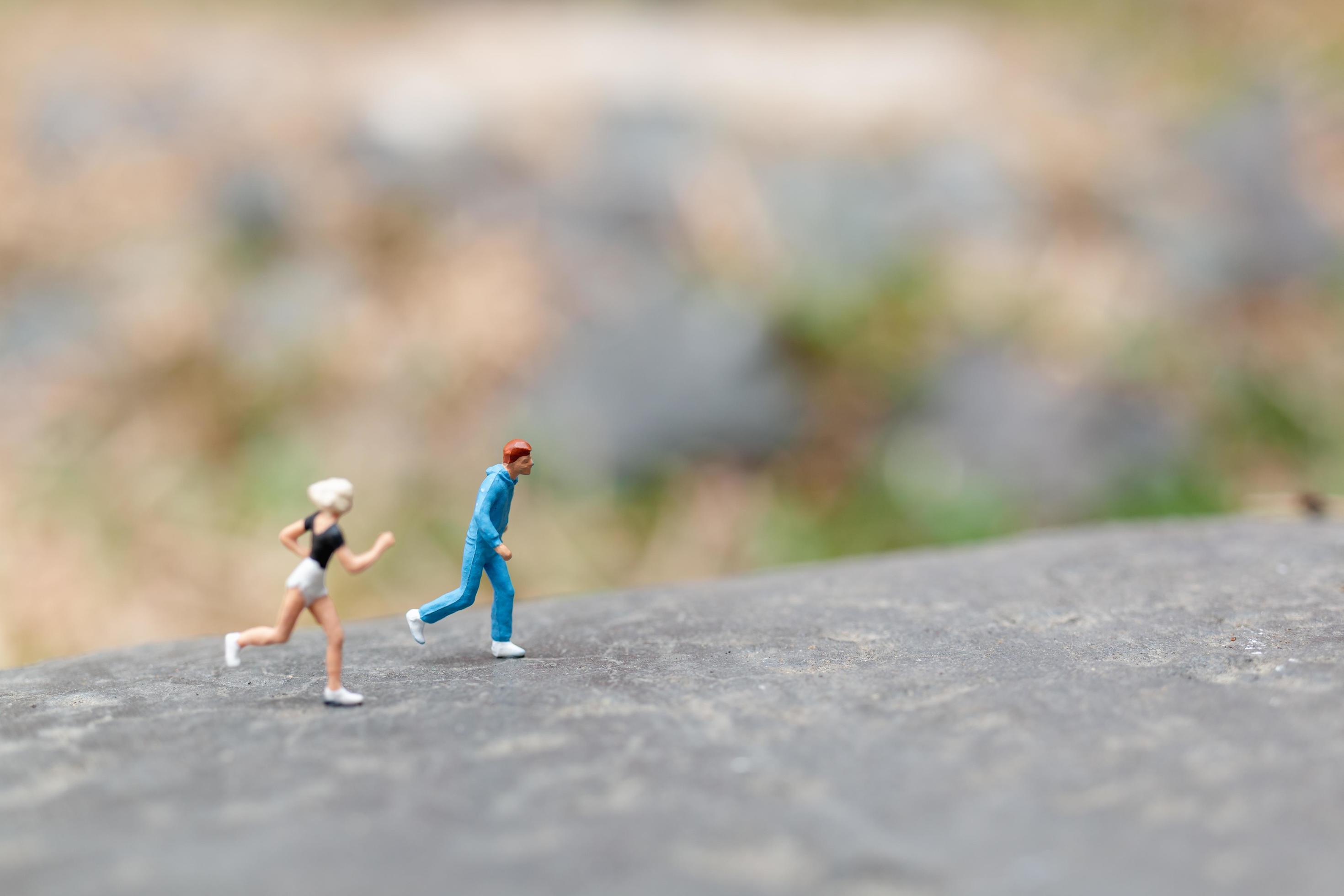 Miniature people running on a rock, health and lifestyle concept Stock Free