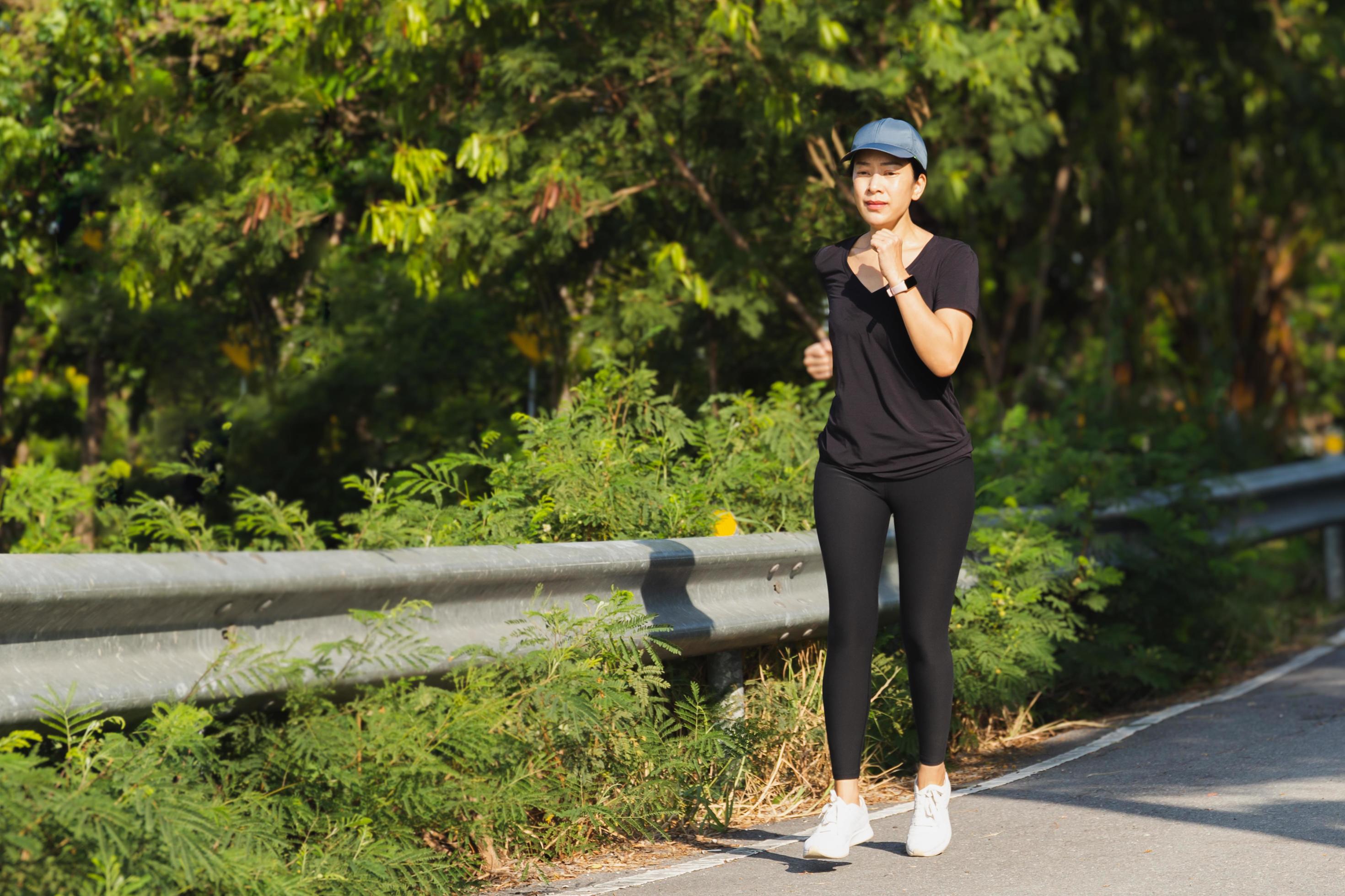 Woman exercise running on the road in the park. Stock Free