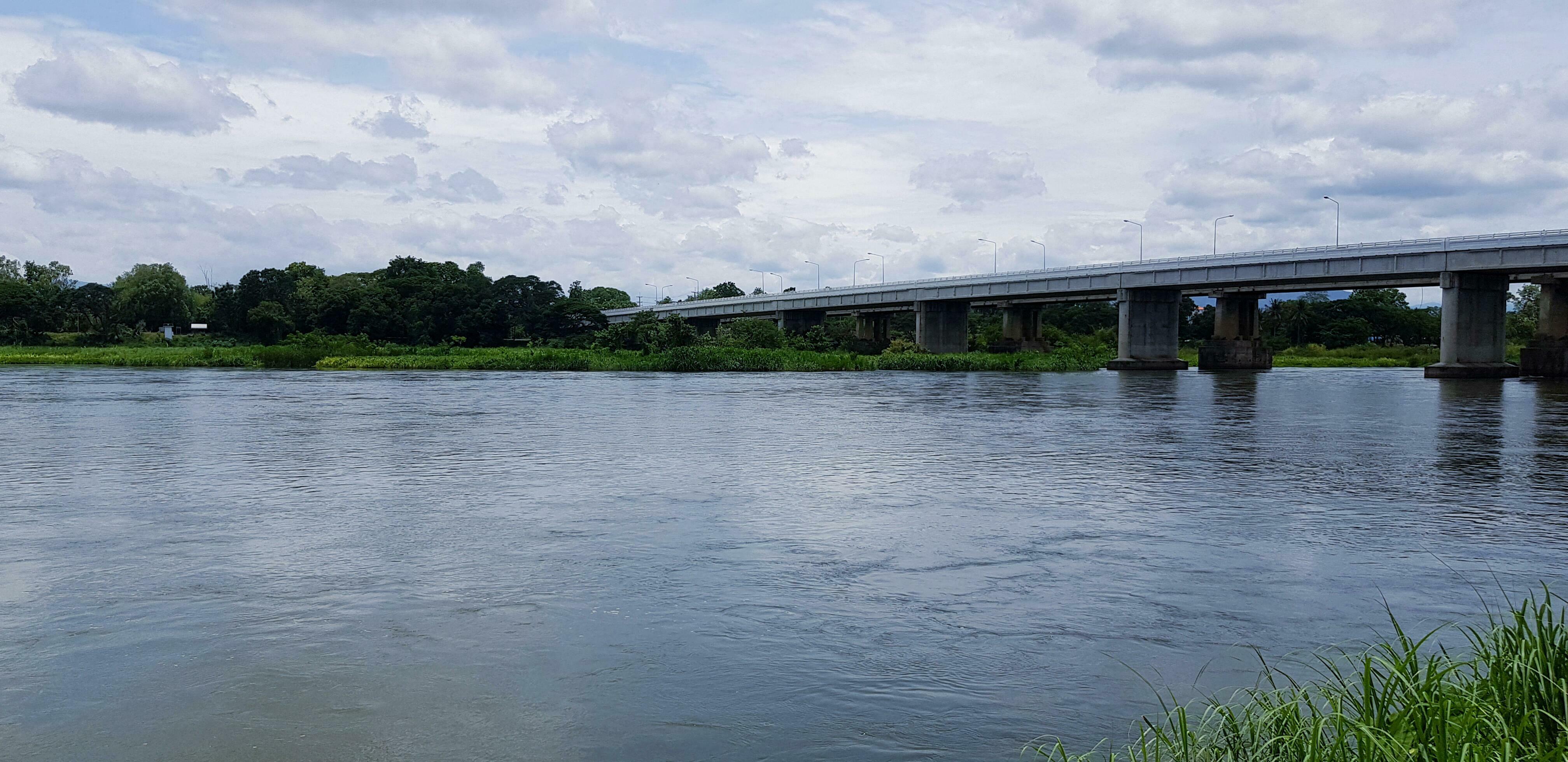 Beautiful river view and tree with a concrete bridge across the river or lake. Construction, Transportation and nature. Stock Free