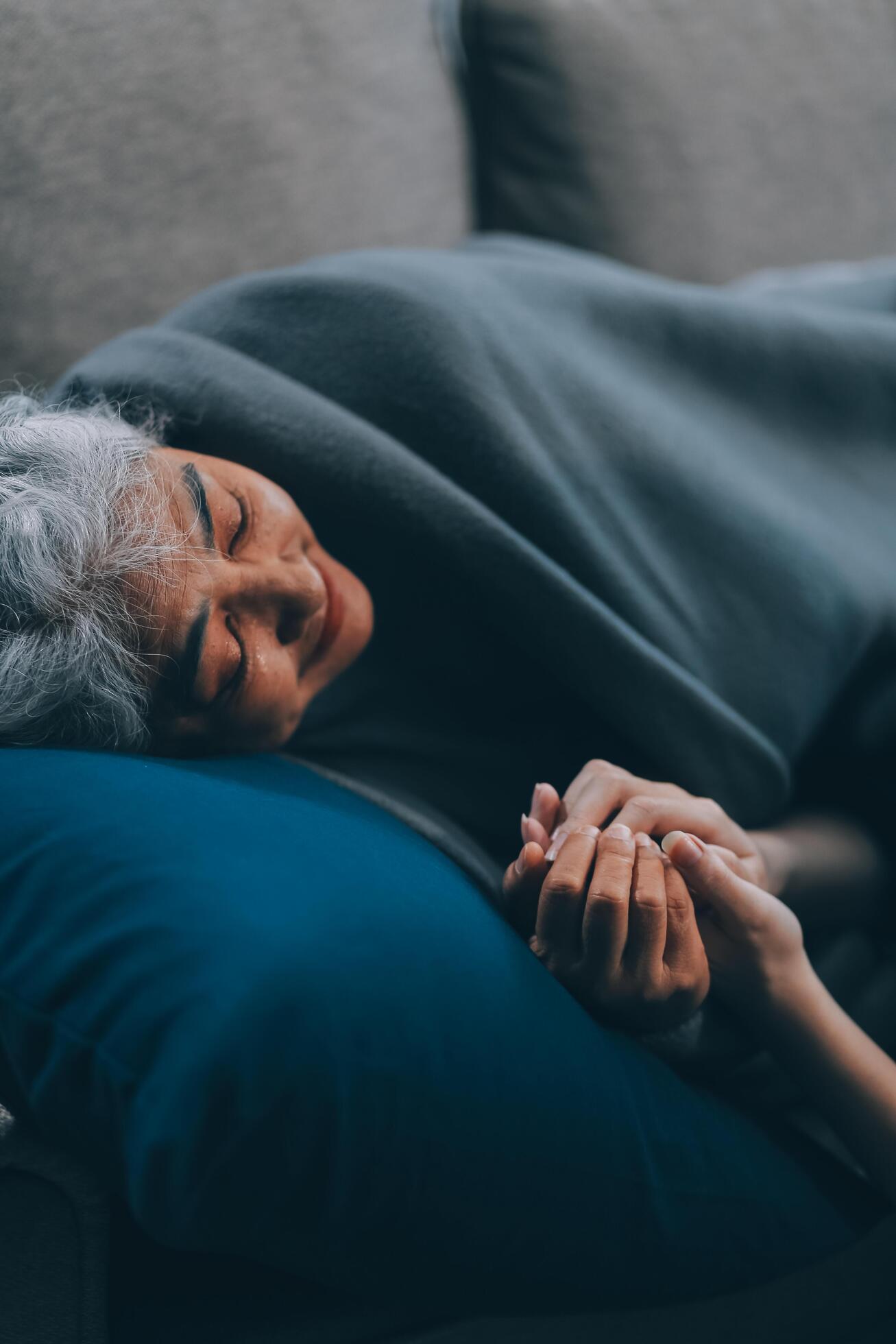 
									happy family Granddaughter takes care of her grandmother with warm cloths sitting on the sofa. Stock Free