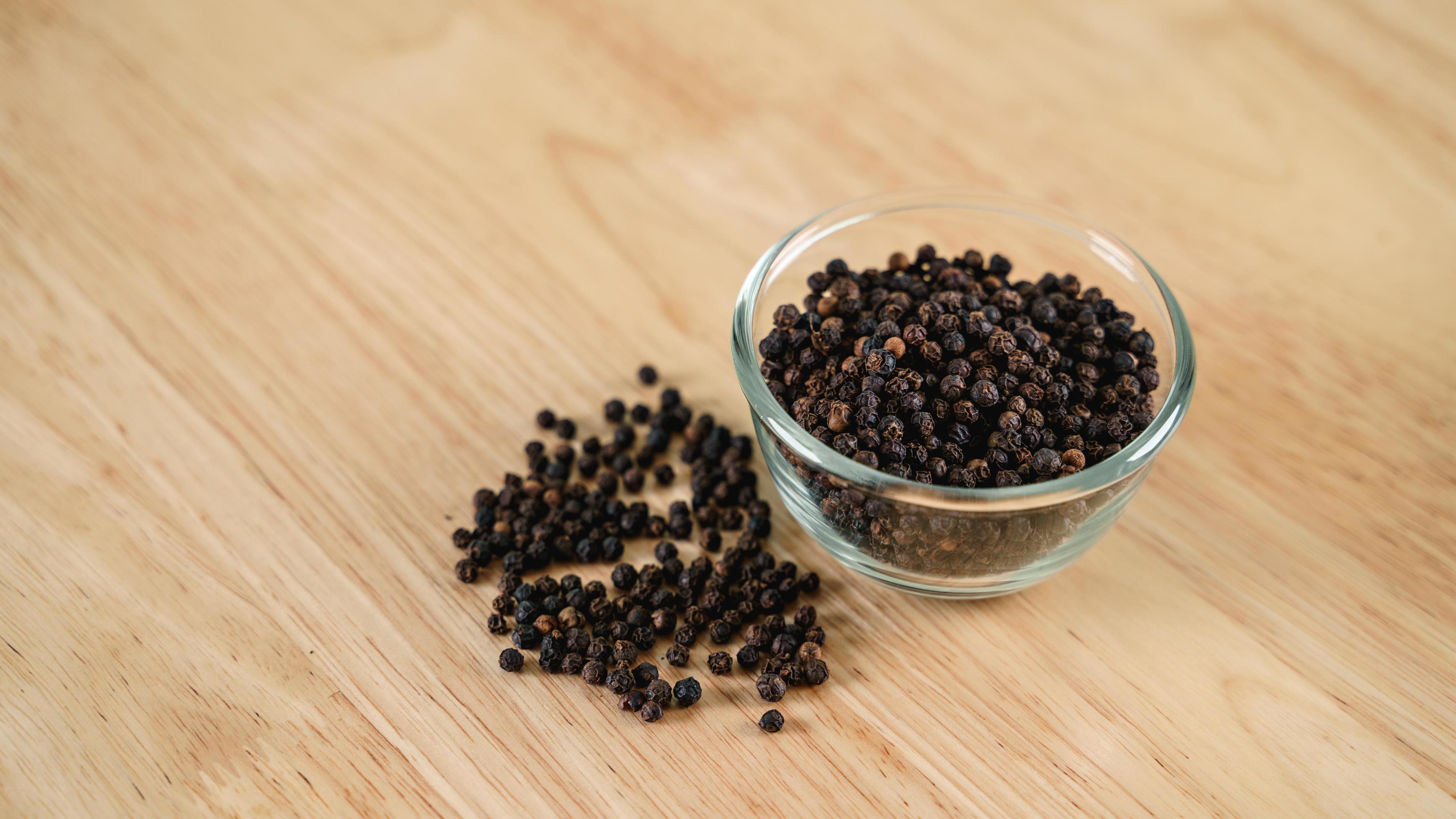 Black pepper in a glass bowl on the wooden table. food, spice, seasoning Concept. Stock Free