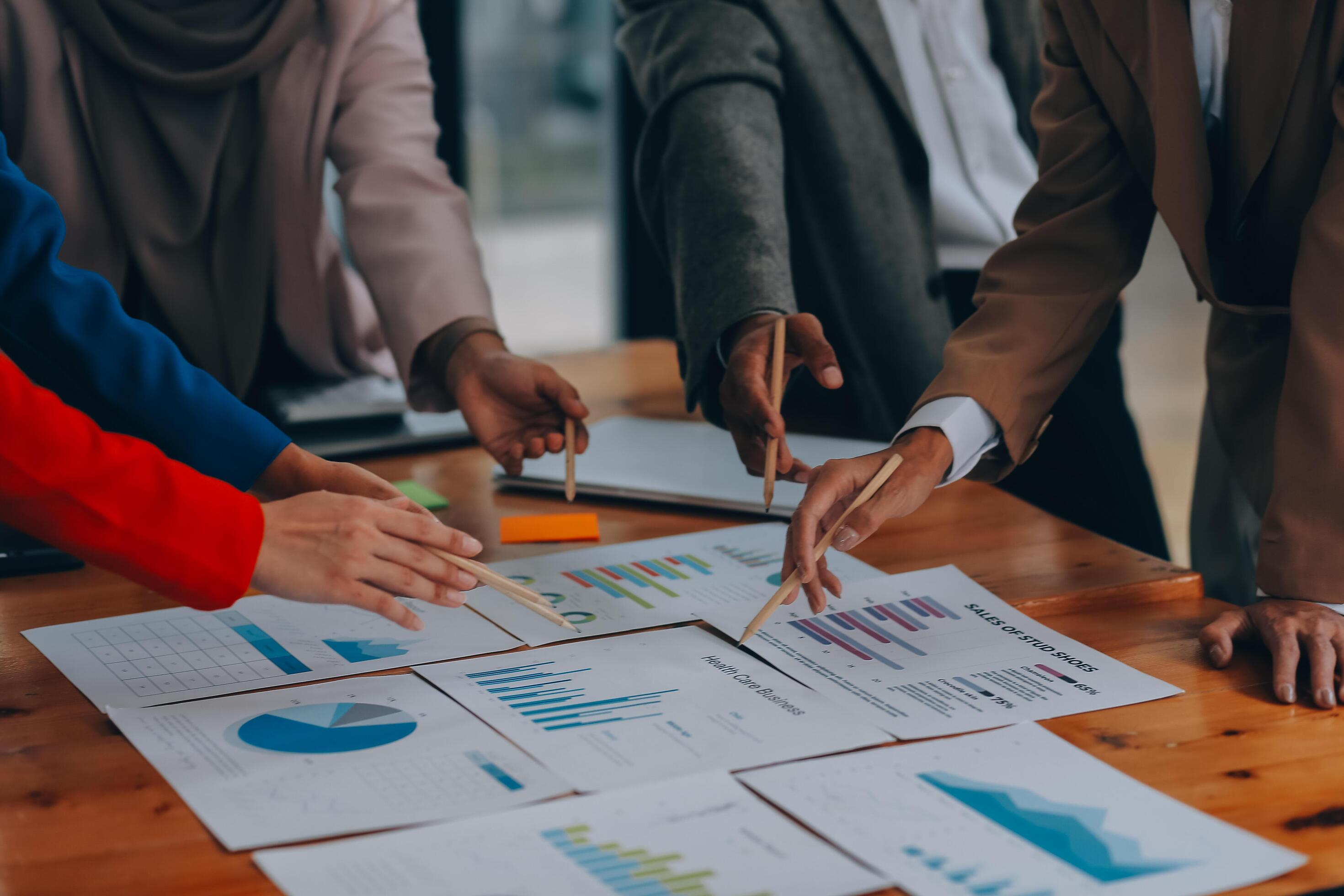 Business professionals. Group of young confident business people analyzing data using computer while spending time in the office Stock Free