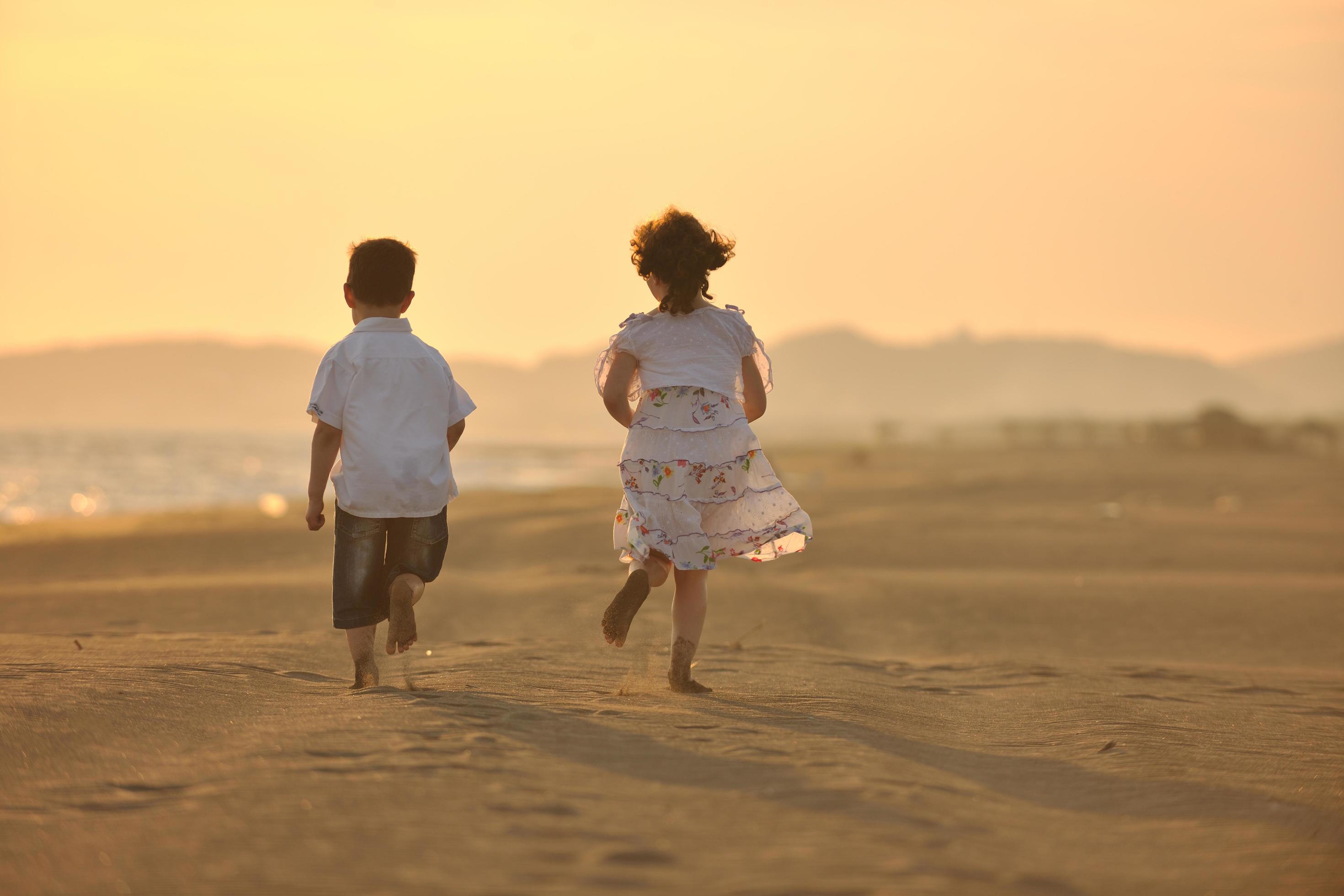 happy young family have fun on beach at sunset Stock Free