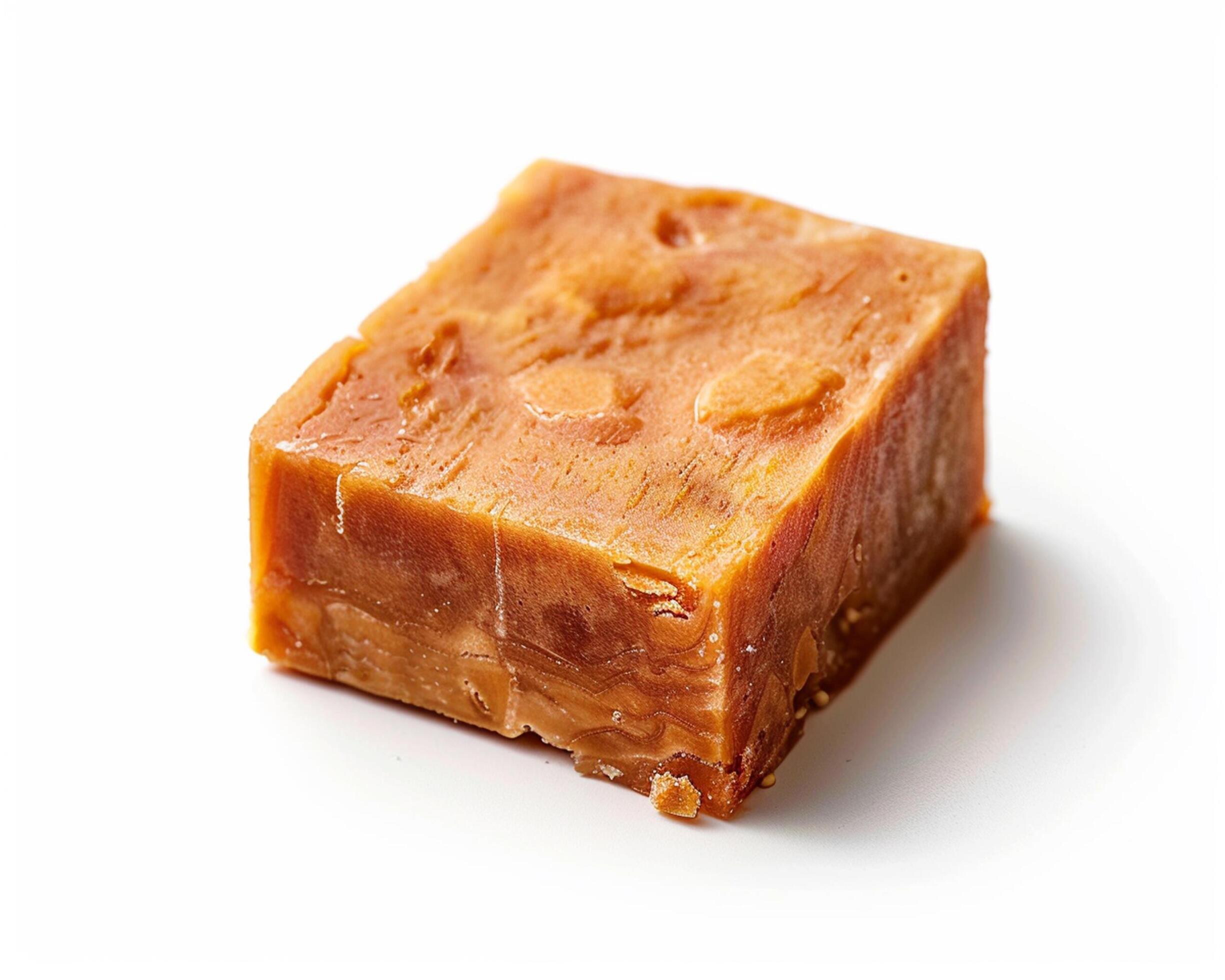 a piece of orange soap on a white surface Stock Free