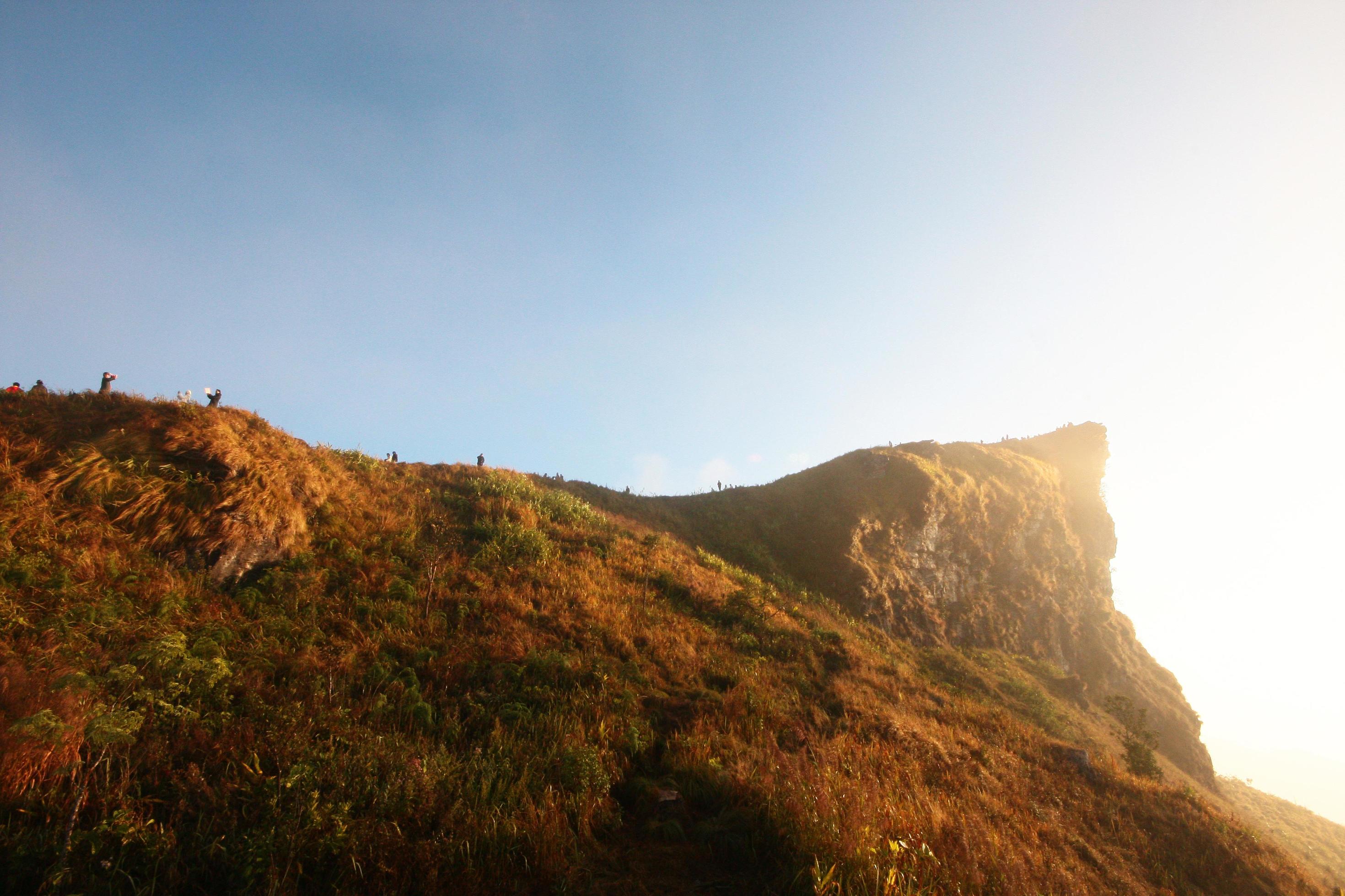 Silhouette tourist in valley of mountain with foggy and mist in winter of sunrise shining on the sky at Phu Chee Fah hill northern of Thailand Stock Free