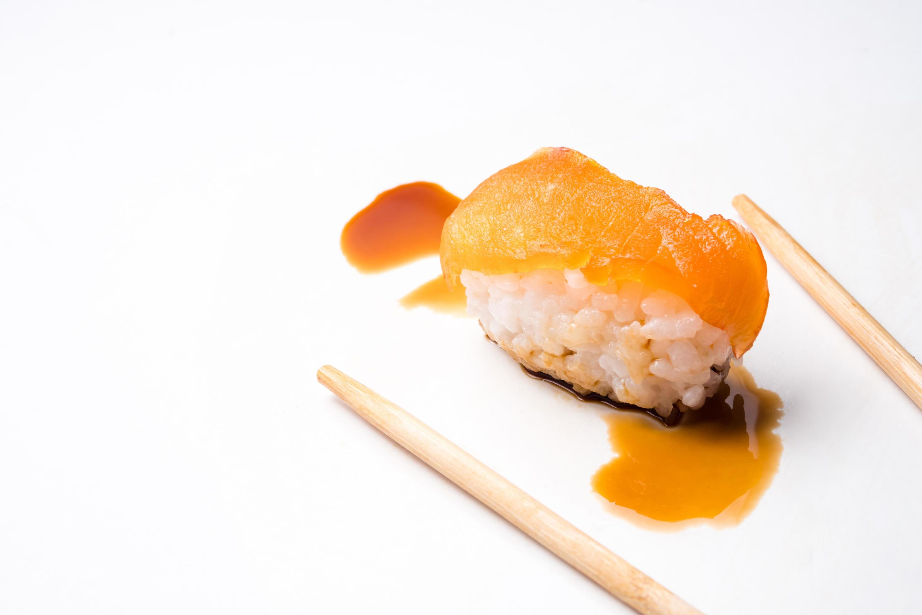 Sushi, japanese food, rice with salmon, chopsticks and sauce on white background. Stock Free