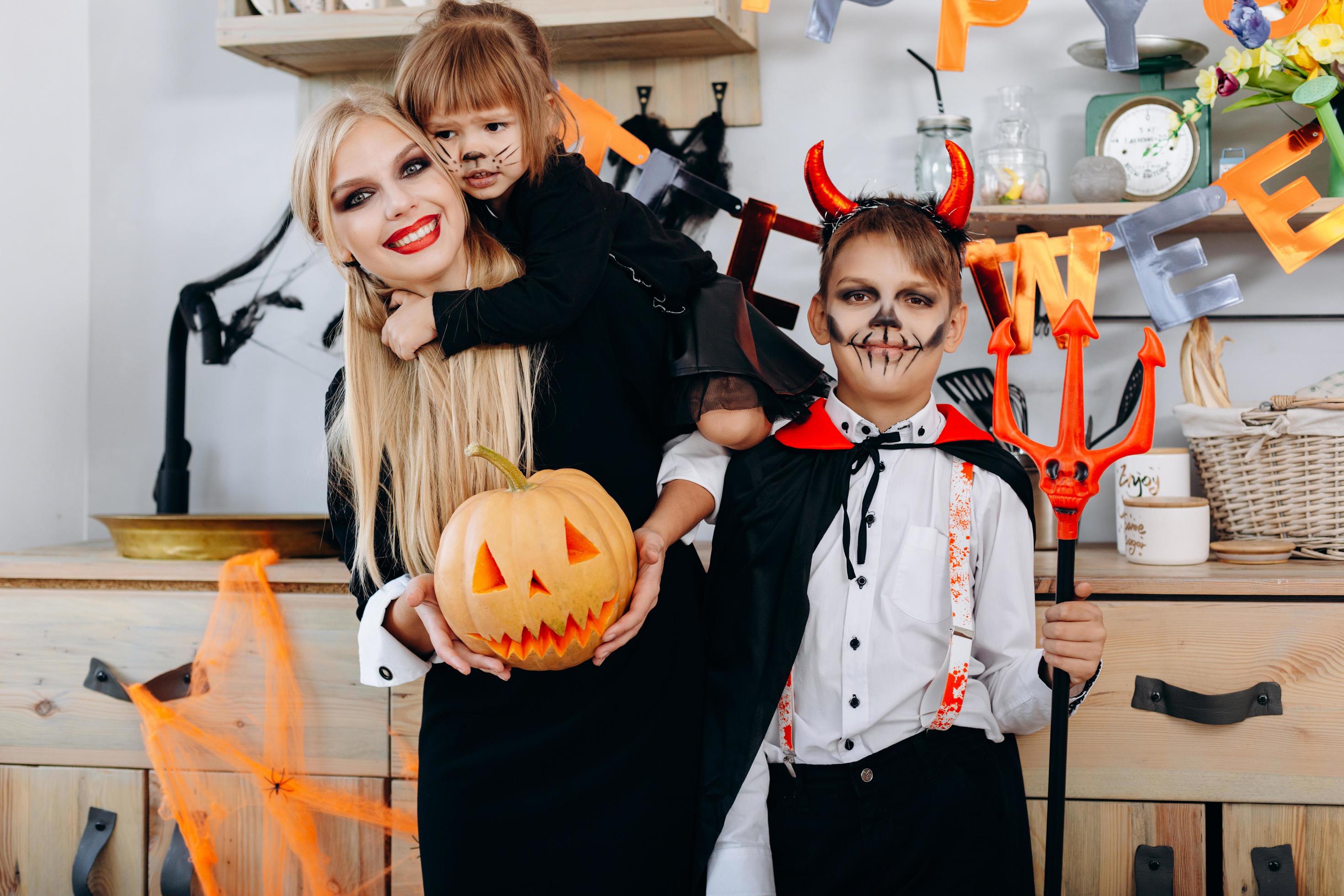 Funny family in the kitchen standing in fancy dress and looking at the camera – Halloween concept Stock Free