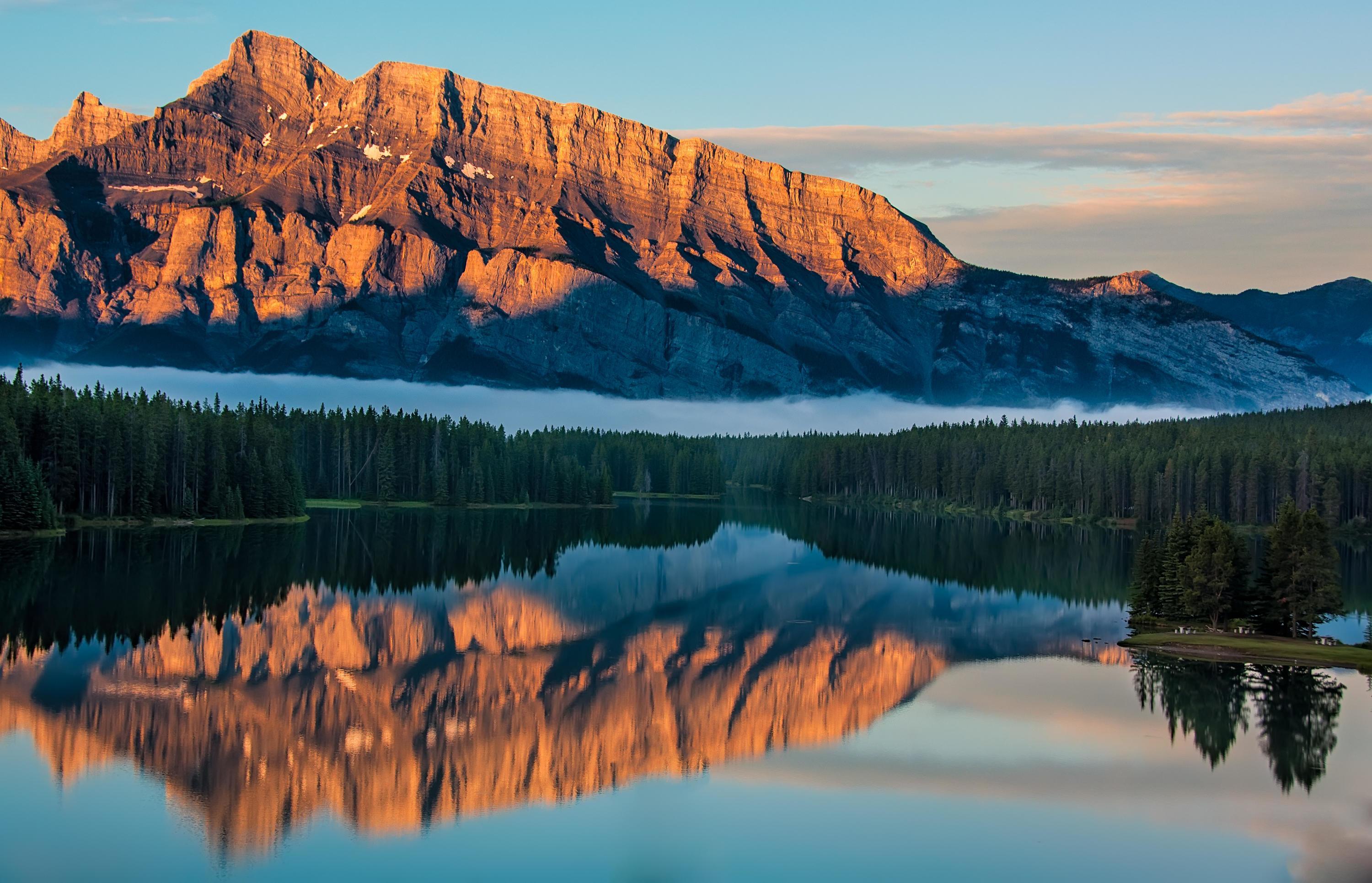 Mountains by body of water at sunset Stock Free