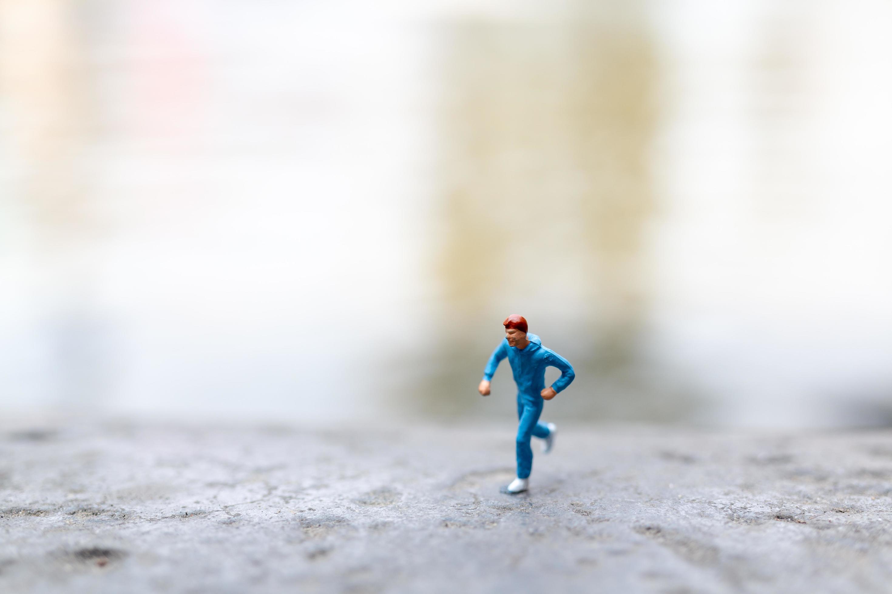 Miniature people running on a rock, health and lifestyle concept Stock Free