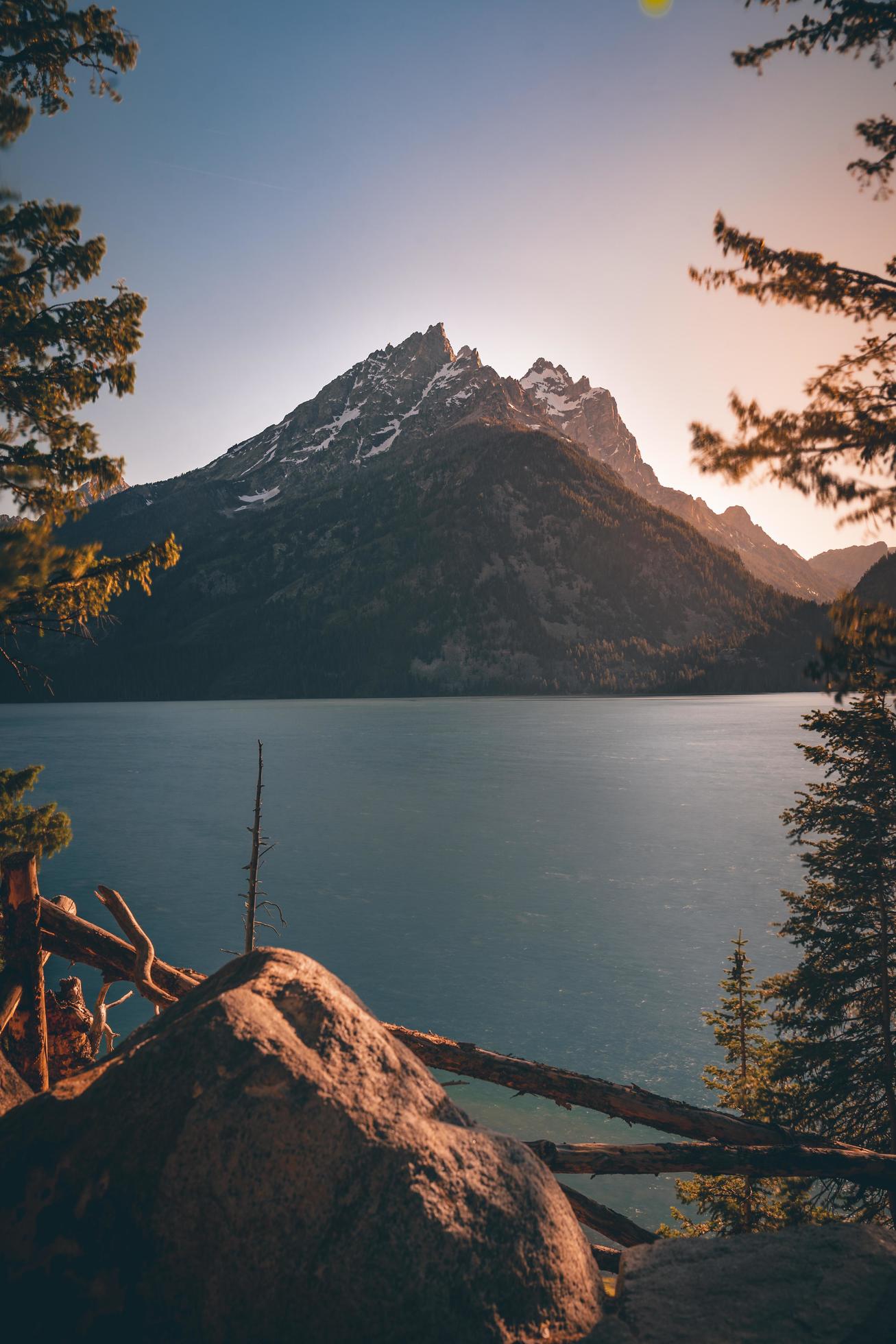 Rocks near body of water and mountain Stock Free